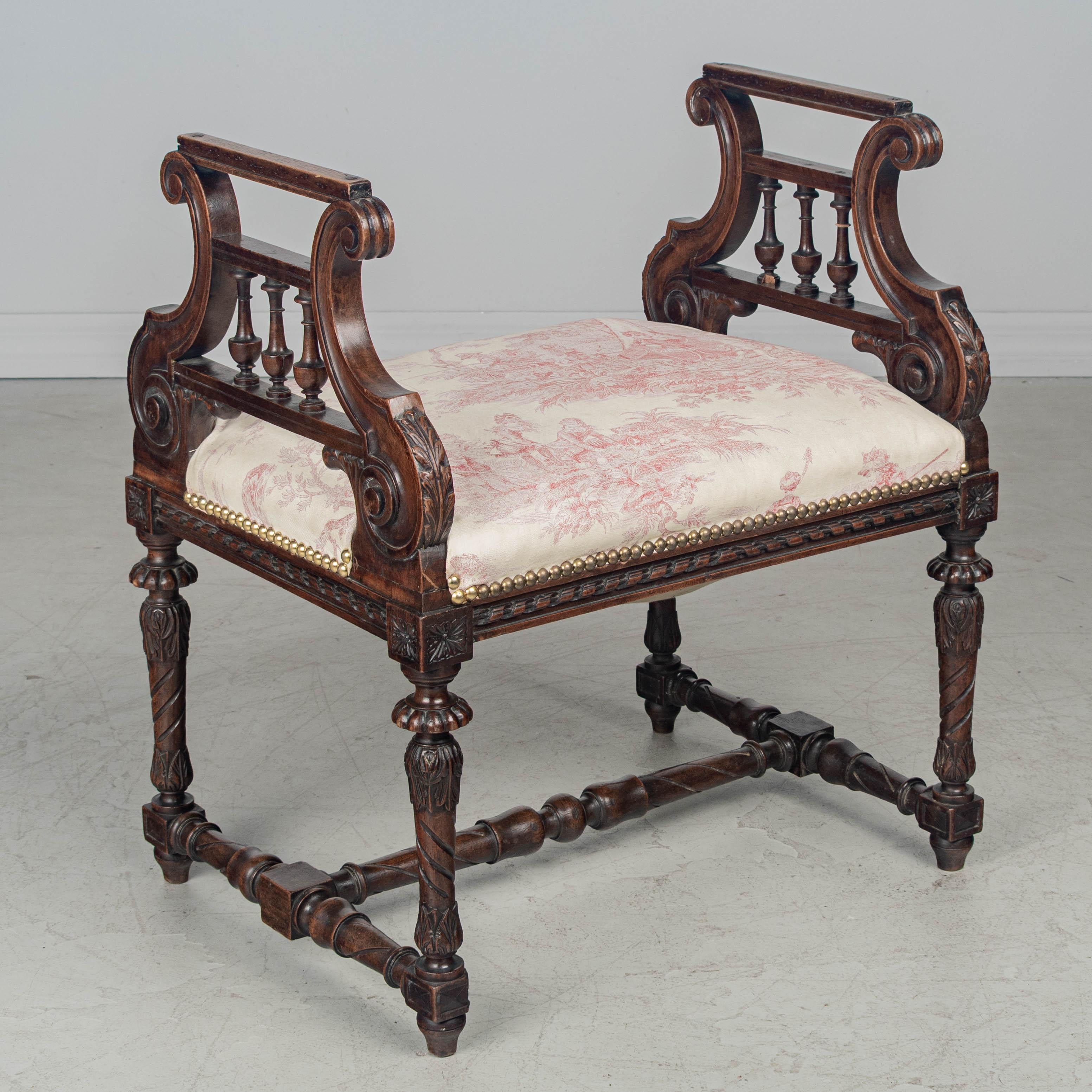 Banco o taburete de piano francés de principios del siglo XX, estilo Luis XV, con armazón de nogal macizo. Bonitos detalles tallados a mano con patas torneadas y decoración de camillas y husos. La tapicería de tela toile se sustituyó posteriormente