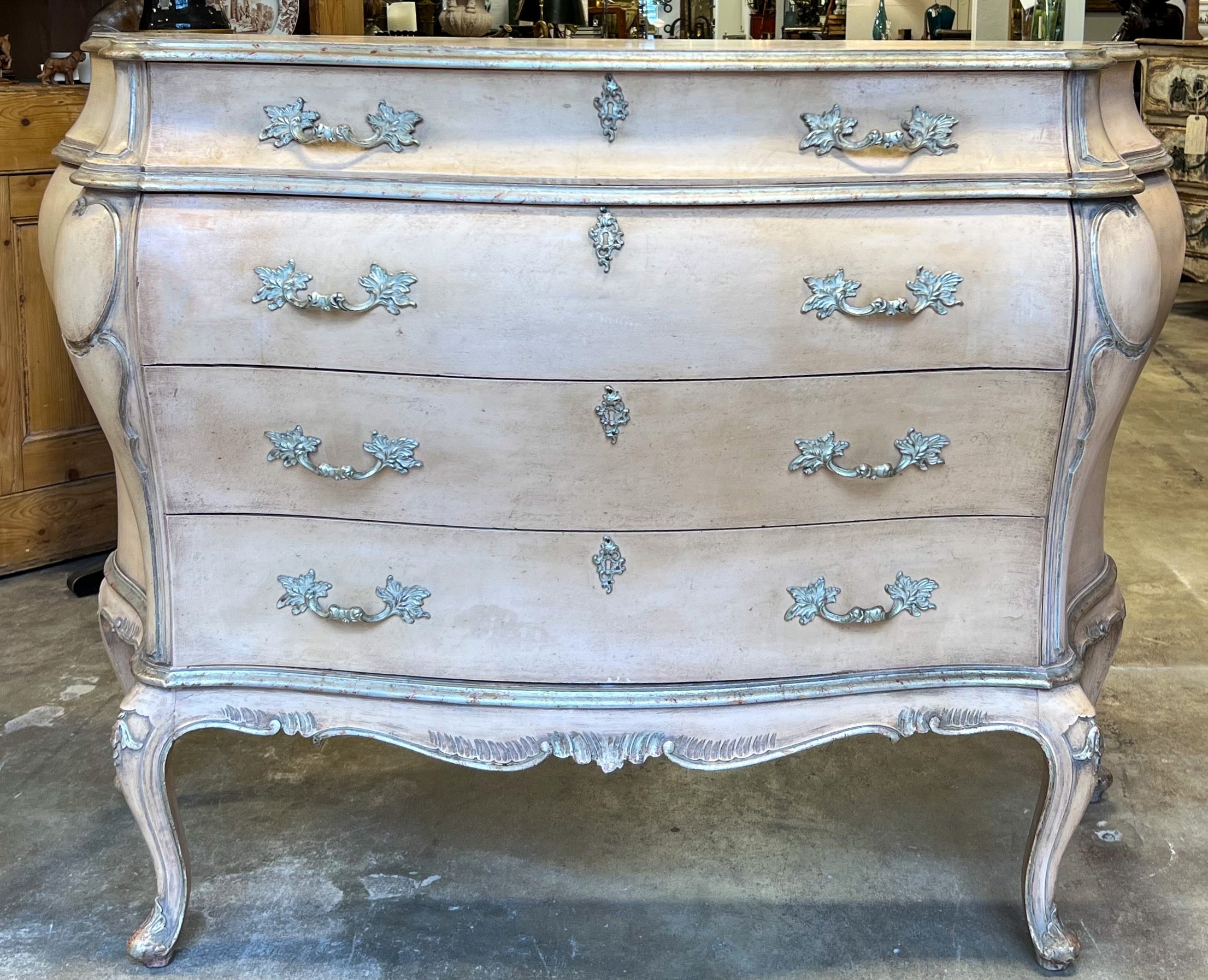 This is a lovely French Louis XV style painted commode with the original painted finish in a combination of a blush pink and silver gilt. When I first analyzed this piece, I was thinking it would be Italian, but its construction and weight has