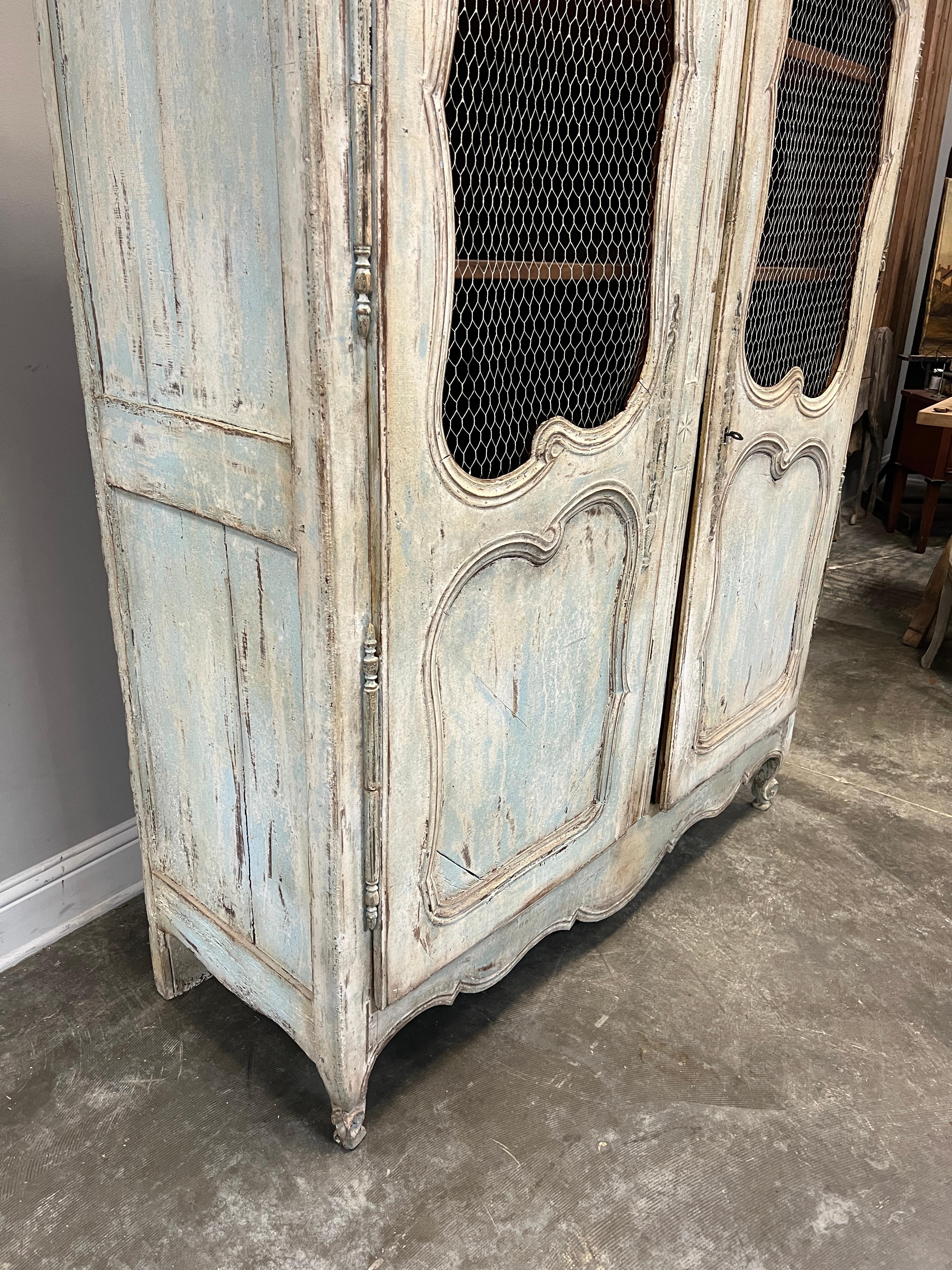 Charming Louis XV style painted armoire with chicken wire, great for display. Color is a cream and aqua color and hardware original.