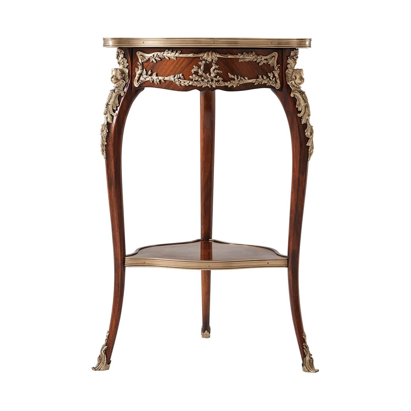 A French Louis XV style mahogany and ormolu mounted occasional table, the brass bound shaped three-sided table top above a rosewood veneered frieze enclosed by foliate mounts, on three cabriole legs with caryatid mounts terminating in sabots, united
