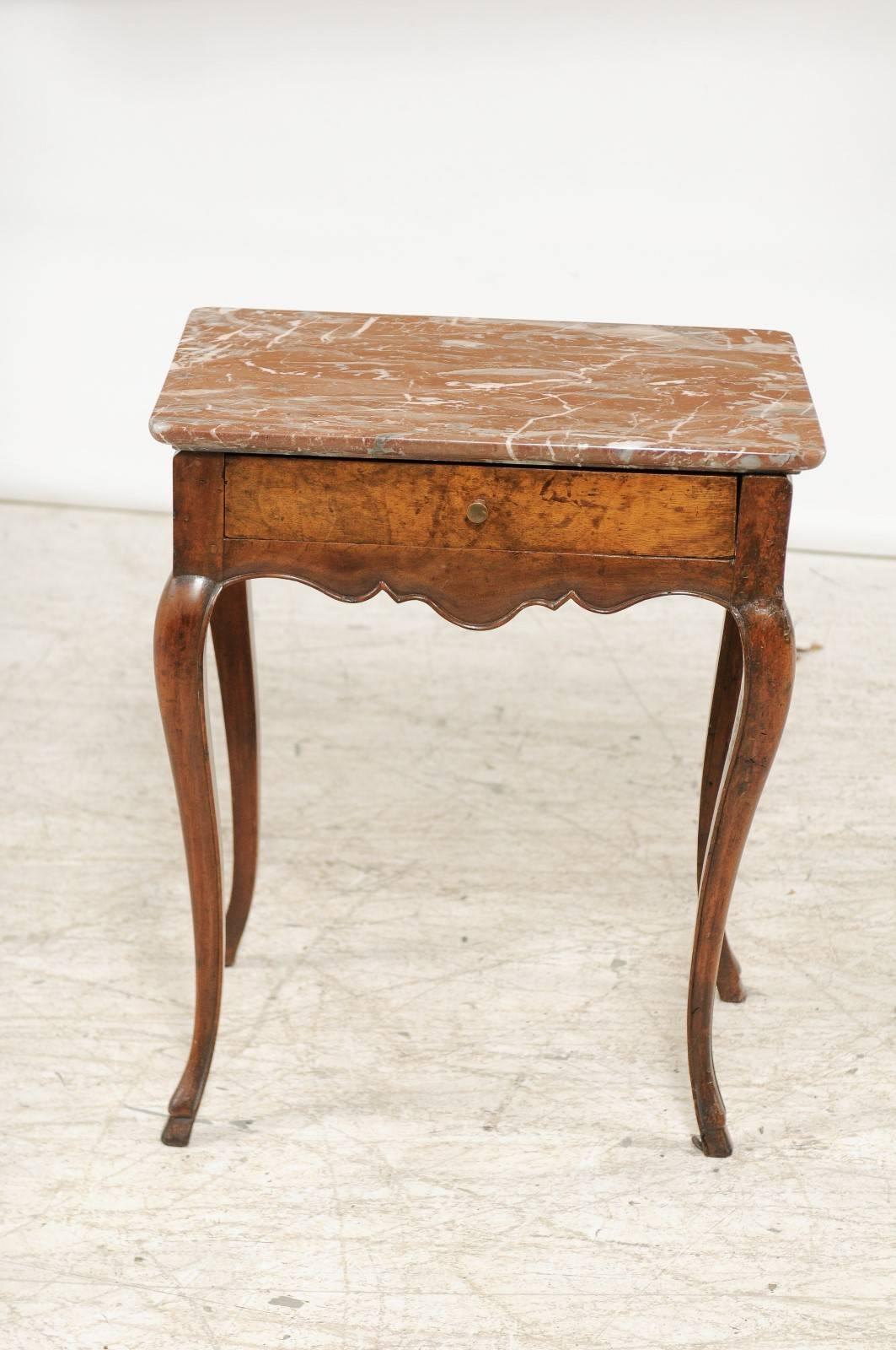 A French Louis XV style wooden side table with red variegated marble top, single drawer and cabriole legs from the late 18th century. This exquisite French Louis XV style side table features a rectangular royal red and white veined marble top over a