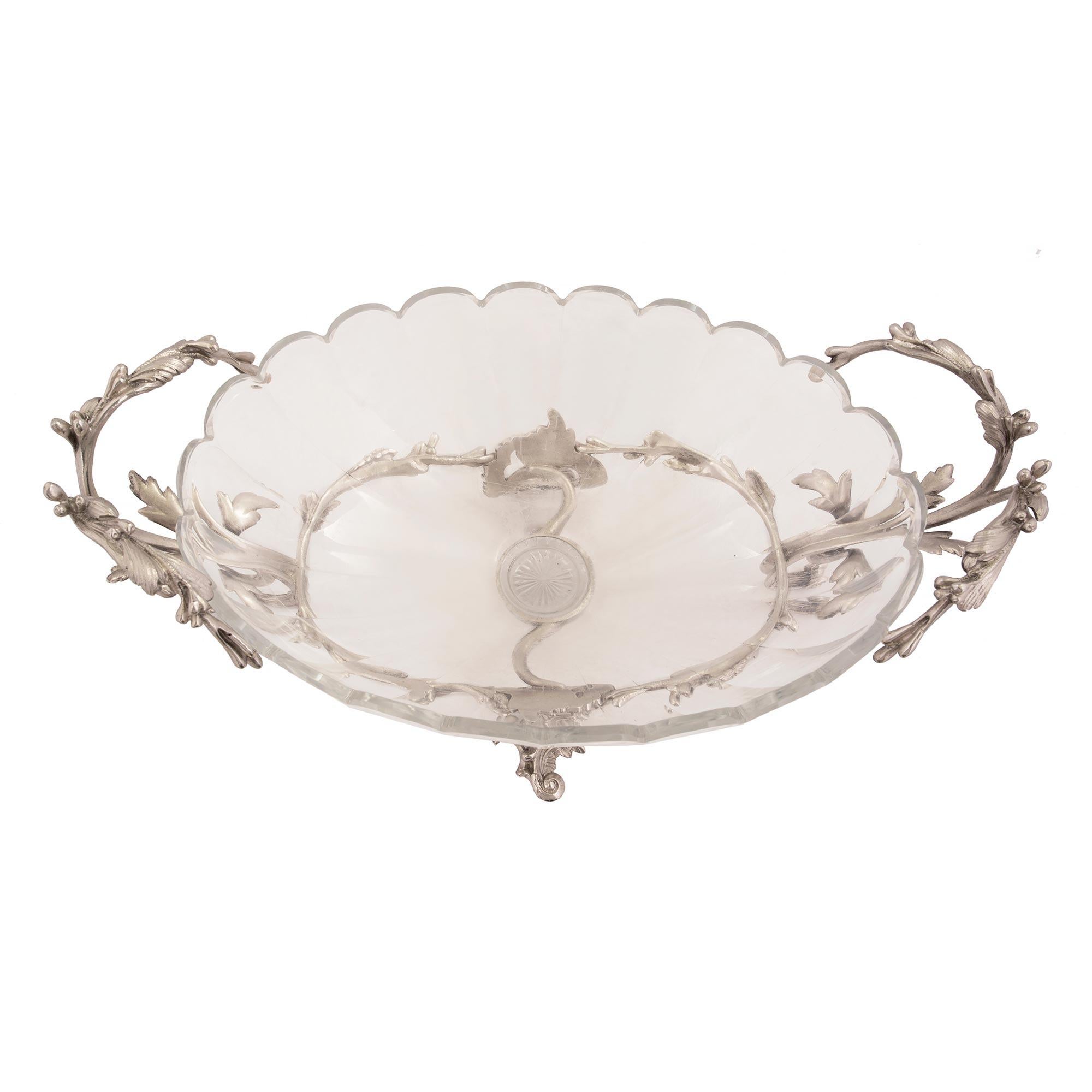 A beautiful French 19th century Louis XV st. silvered bronze and Baccarat crystal centerpiece. The centerpiece is raised by striking scrolled foliate supports with elegant and most charming movements. Leading up each side are scrolled arms with