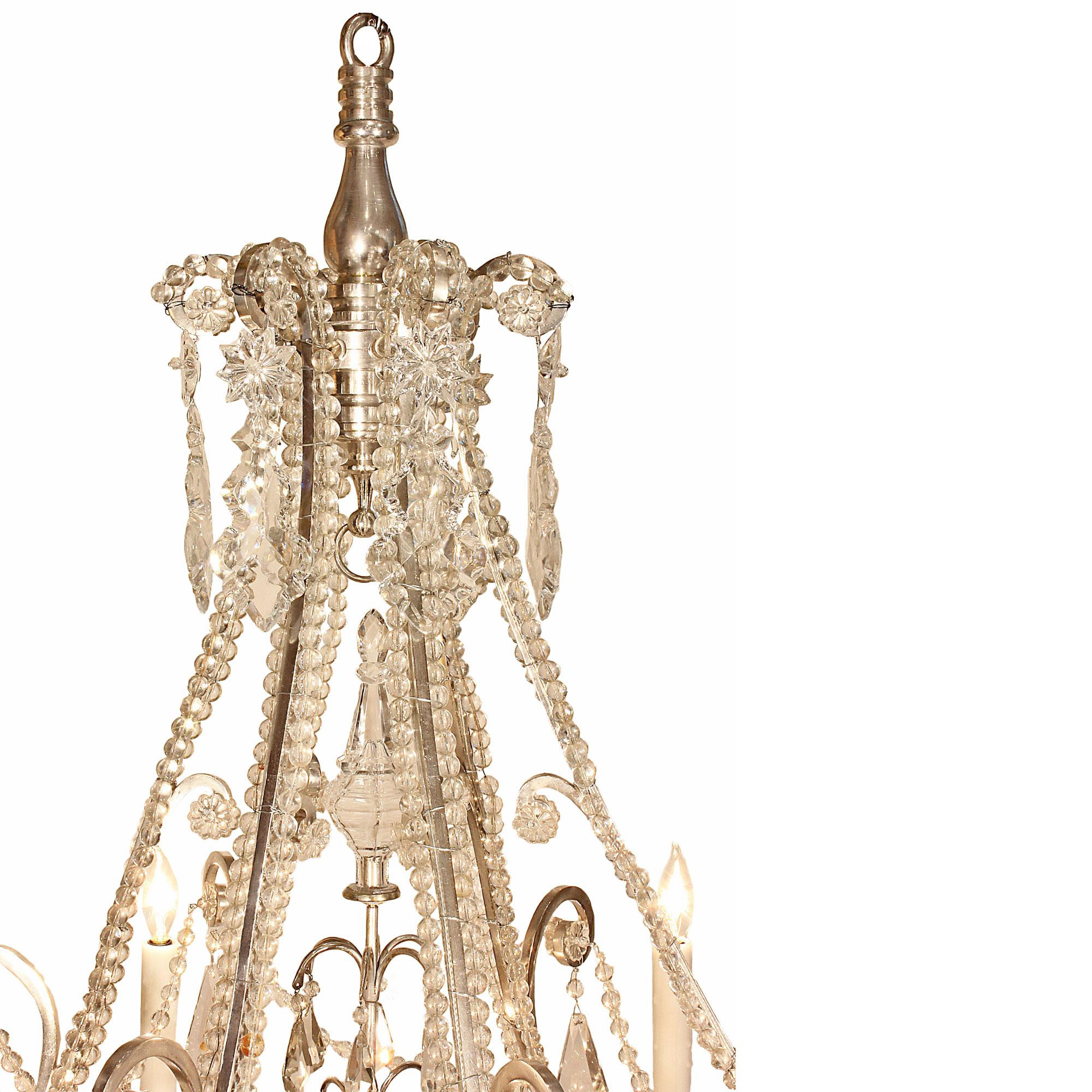 A very elegant and unique French 19th century Louis XV st. silvered bronze and Baccarat crystal chandelier. The chandelier had a scrolled silver base with impressive Baccarats crystal pendants centered by a large crystal sphere below smaller beads.