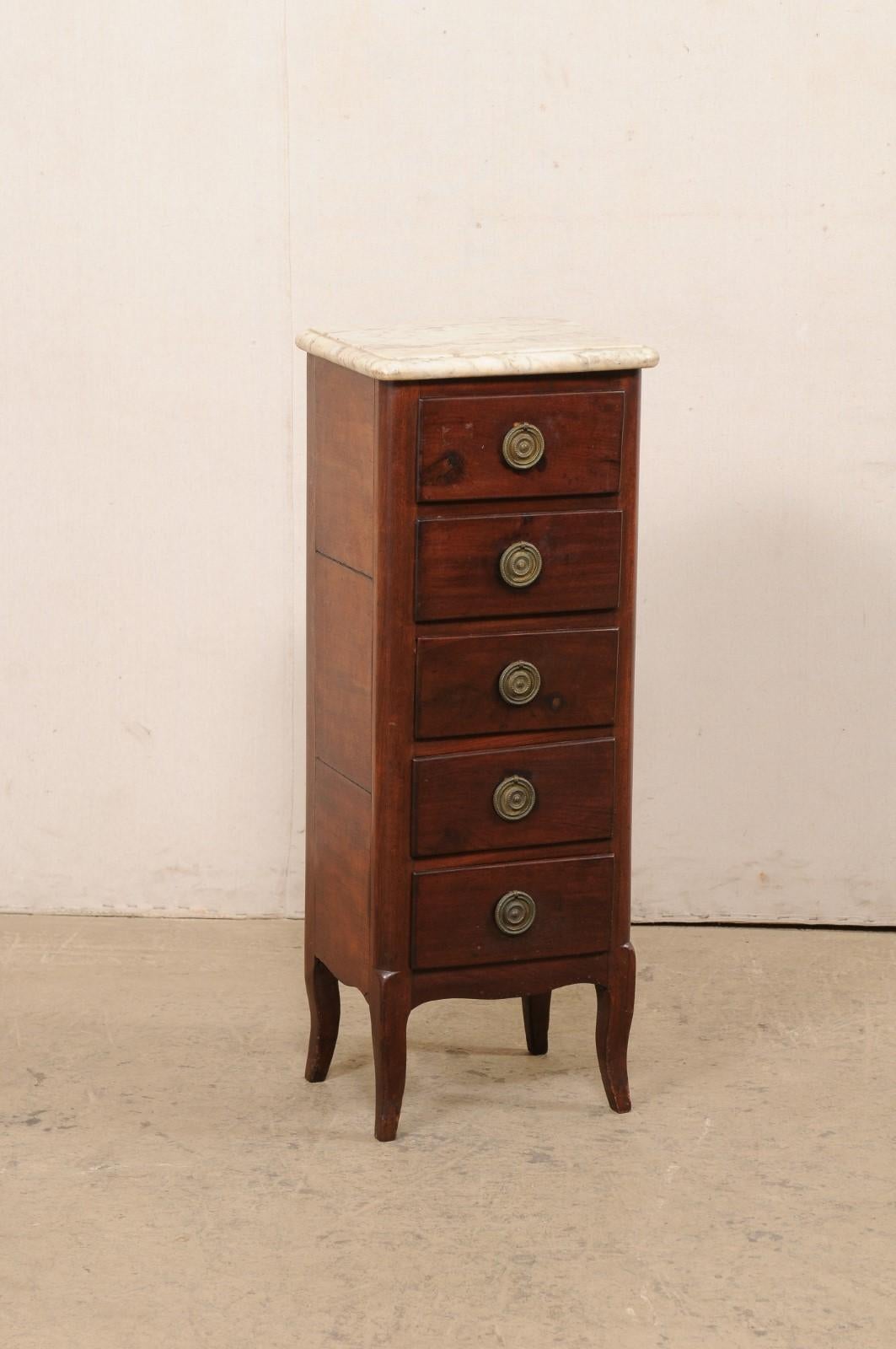 A French Louis XV style wood lingerie chest, with marble top and five drawers, from the 19th century. This antique small-sized commode from France features its original marble top, walnut wood case which houses five drawers set in vertical fashion,