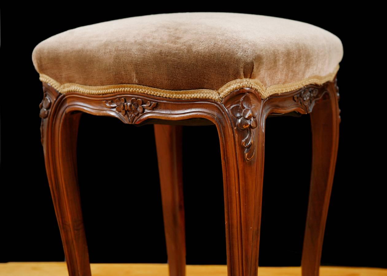 A very lovely Louis XV-style stool in walnut with carved flowers along apron and knees, with carved cabriole legs and upholstered square seat, France, circa 1900.
Measures: 17