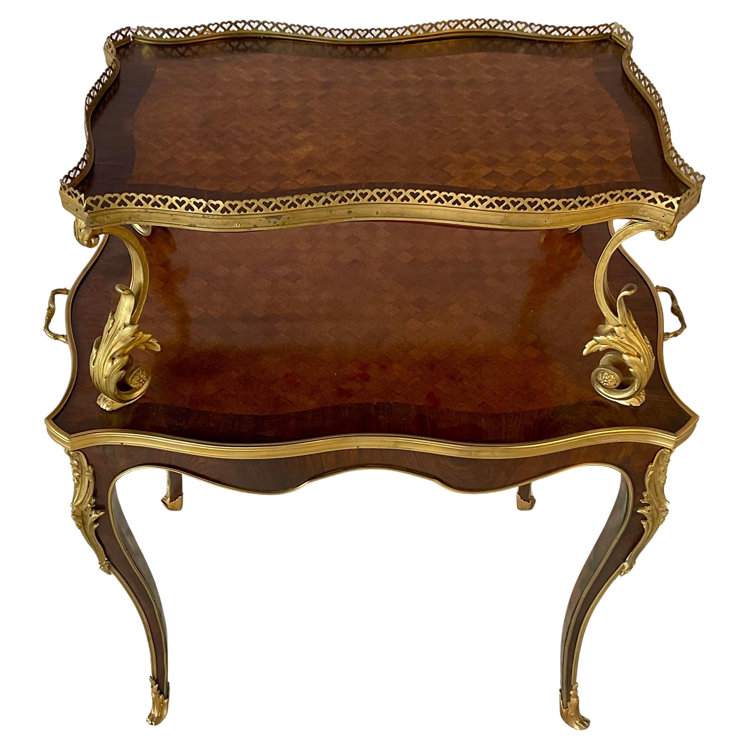 Tavolo da dessert o da portata francese a due piani della fine del XIX secolo in stile Luigi XV. Il tavolo presenta un'elegante forma a bombe e gambe a cabriole ed è decorato con decorazioni in bronzo dorato, volute d'acanto e sabot. Entrambi i