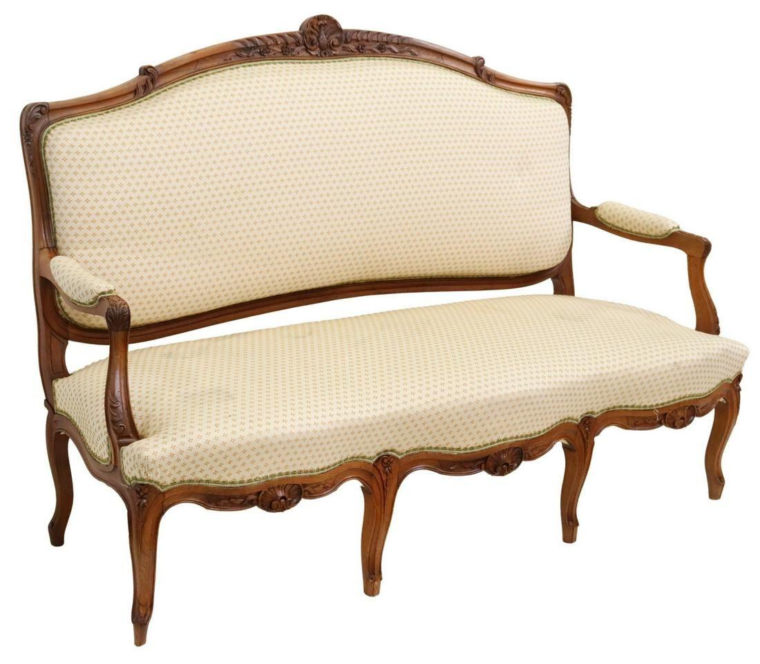Französisches Sofa im Louis XV-Stil, 20. Jh., mit geschnitztem Rocaillekamm in floralem Polster, mit blattförmigen Griffen, über einer Schürze mit Muschelmotiv, auf Cabriole-Beinen stehend, auf Quirlfüßen endend. Polstermöbel in sehr gutem