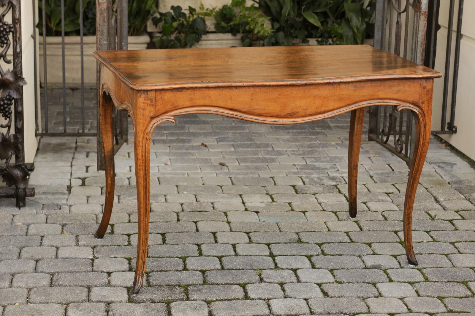 A French Louis XV style walnut console table from the early 19th century, with cabriole legs. Born in France during the Restauration period that saw the temporary return of the Bourbon monarchy, this exquisite walnut console table presents the