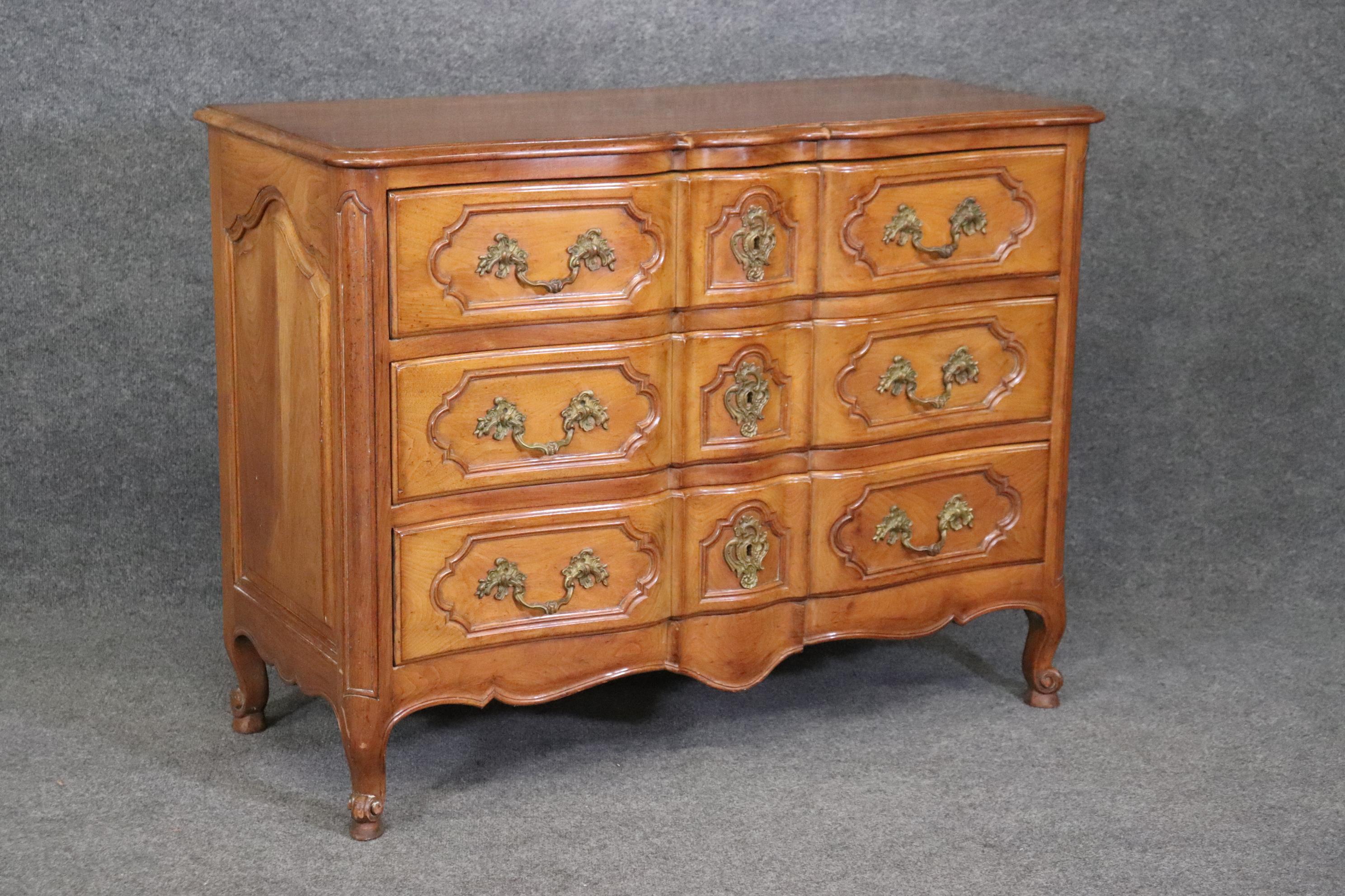 This is a superb, extremely high quality solid walnut and oak commode attributed to Auffray Furniture. The piece is beautifully designed and has faux distressting to make it look like an actual antique. The piece has bronze hardware and is in good