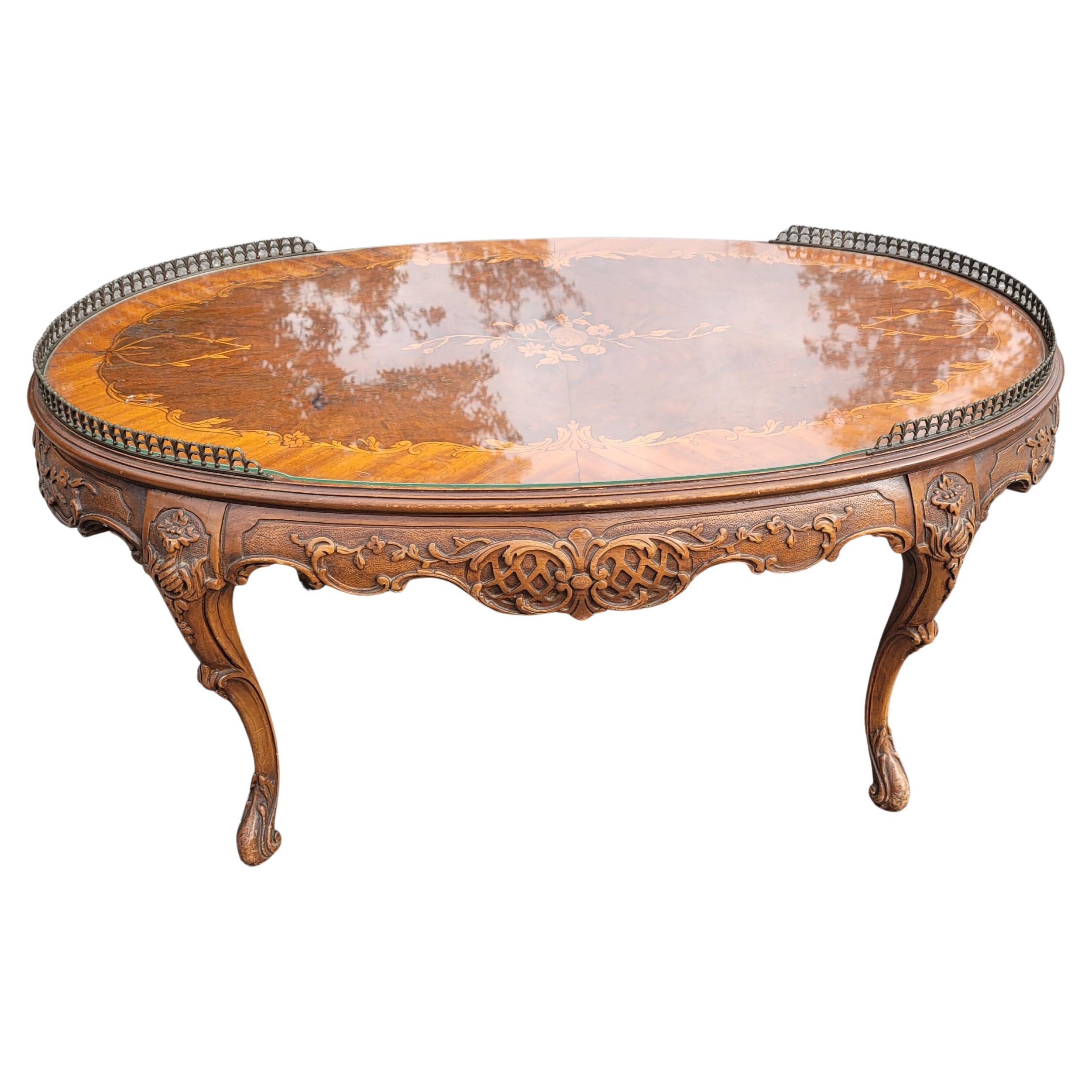 Lovely French Louis XV intricately carved walnut side petite oval coffee table having gorgous inlay floral marquetry decoration and partial sides Gallery. Comes with a Protective Glass Top.
Measures 37