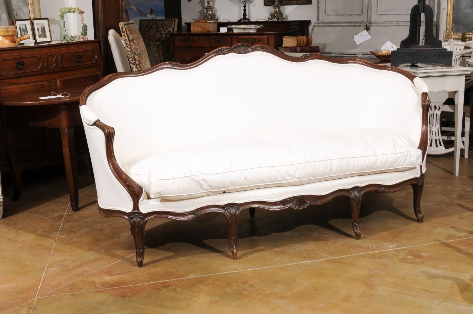 Carved French Louis XV Style Walnut Upholstered Canapé with Wraparound Back, circa 1850 For Sale