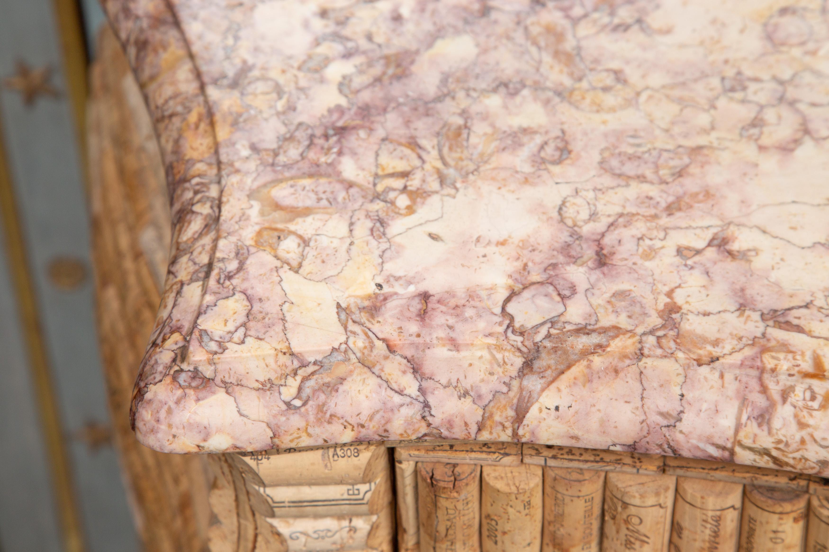 This is a unique French Louis XV style commode, veneered over-all with wine corks. The commode has a variegated pink marble top has an ogee edge over three long drawers and shaped apron; raised on cabriole legs. Perfect for a wine cellar.