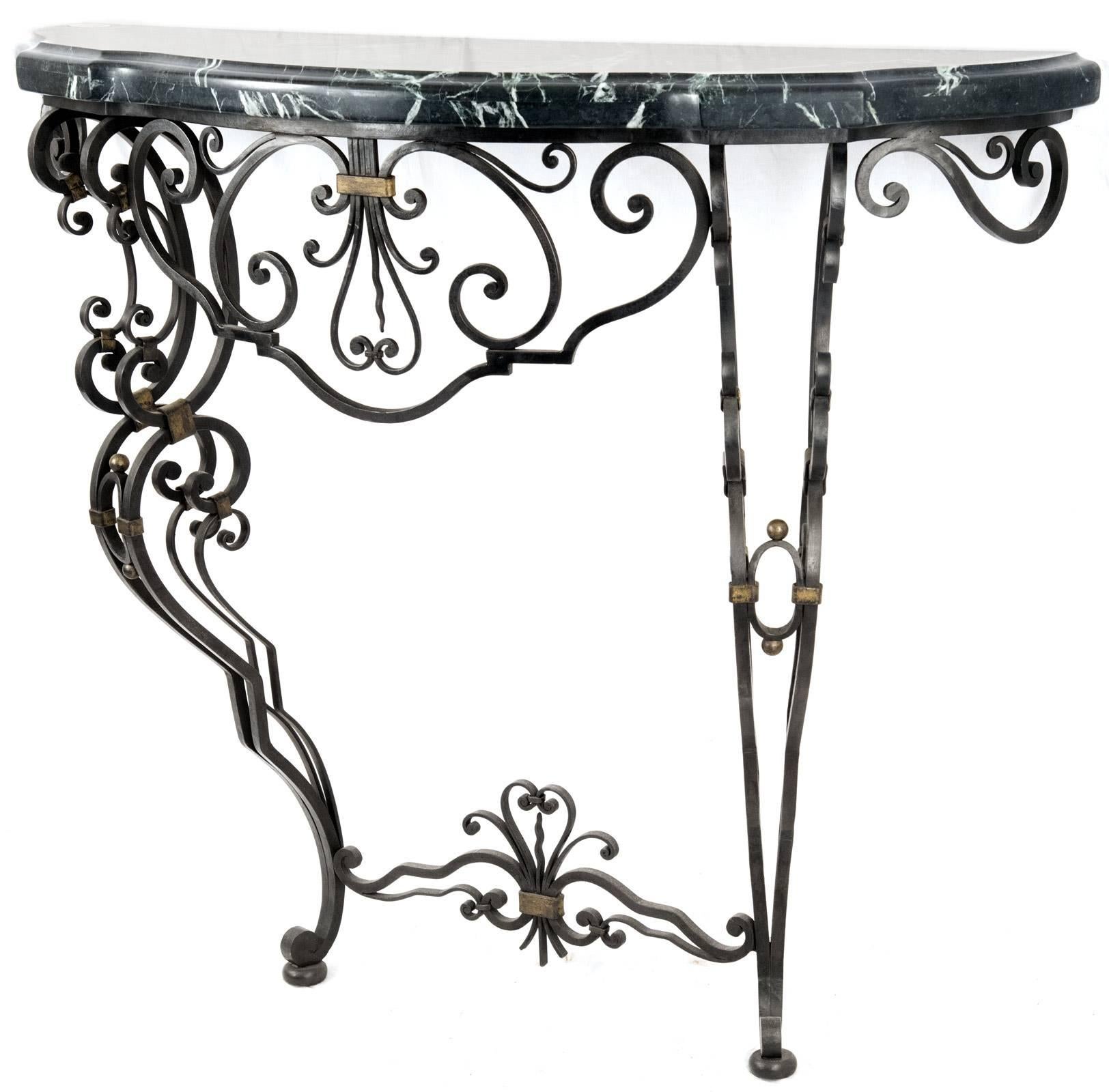 An early 20th century Louis XV style French console table with a wrought iron base with c-scrolled legs and copper details terminating in scrolled feet, surmounted with a cut and beveled serpentine veined green marble top.