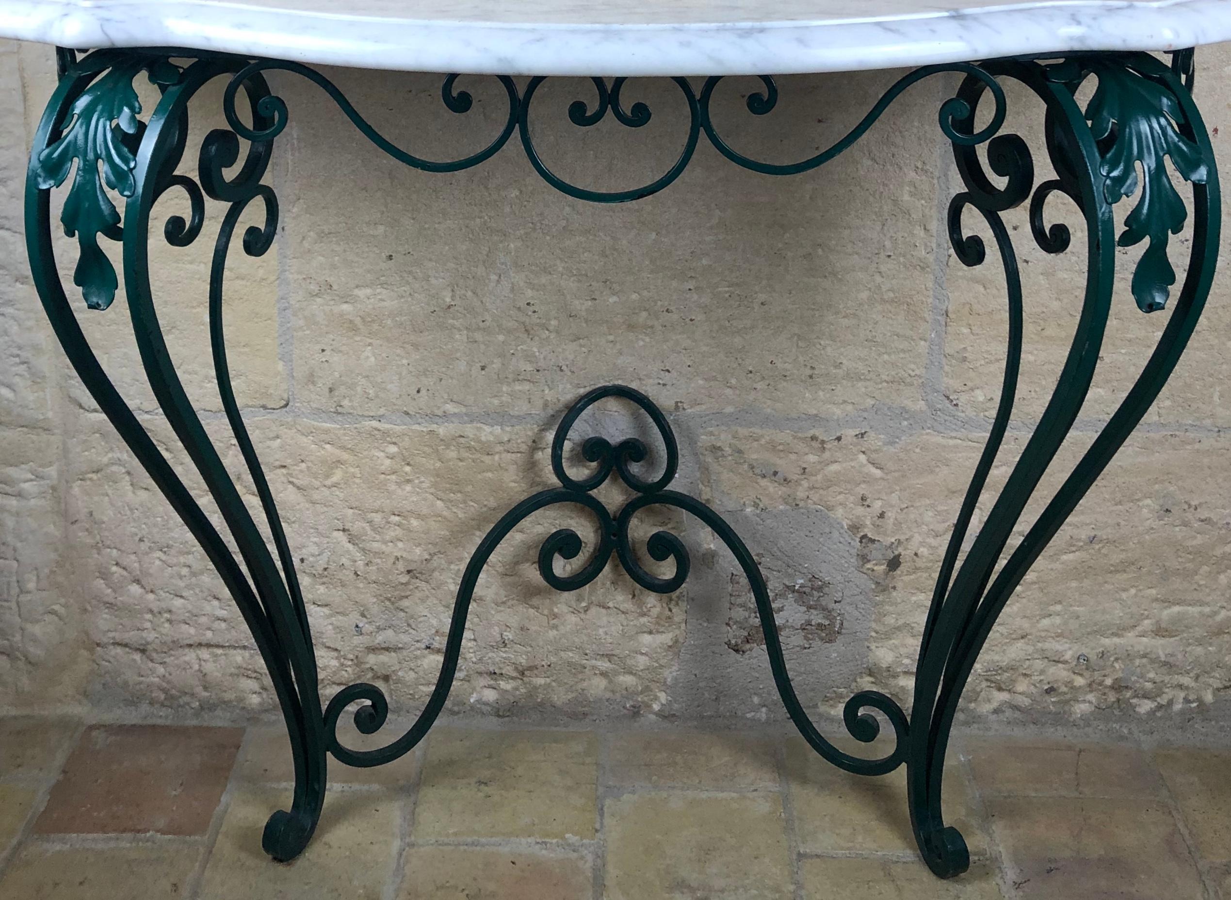 An elegantly formed Louis XV style wrought iron base and a serpentine shaped white Carrera marble top, circa 1950.

Good iron work and easy to fasten to the wall.
Measures: 42 1/2
