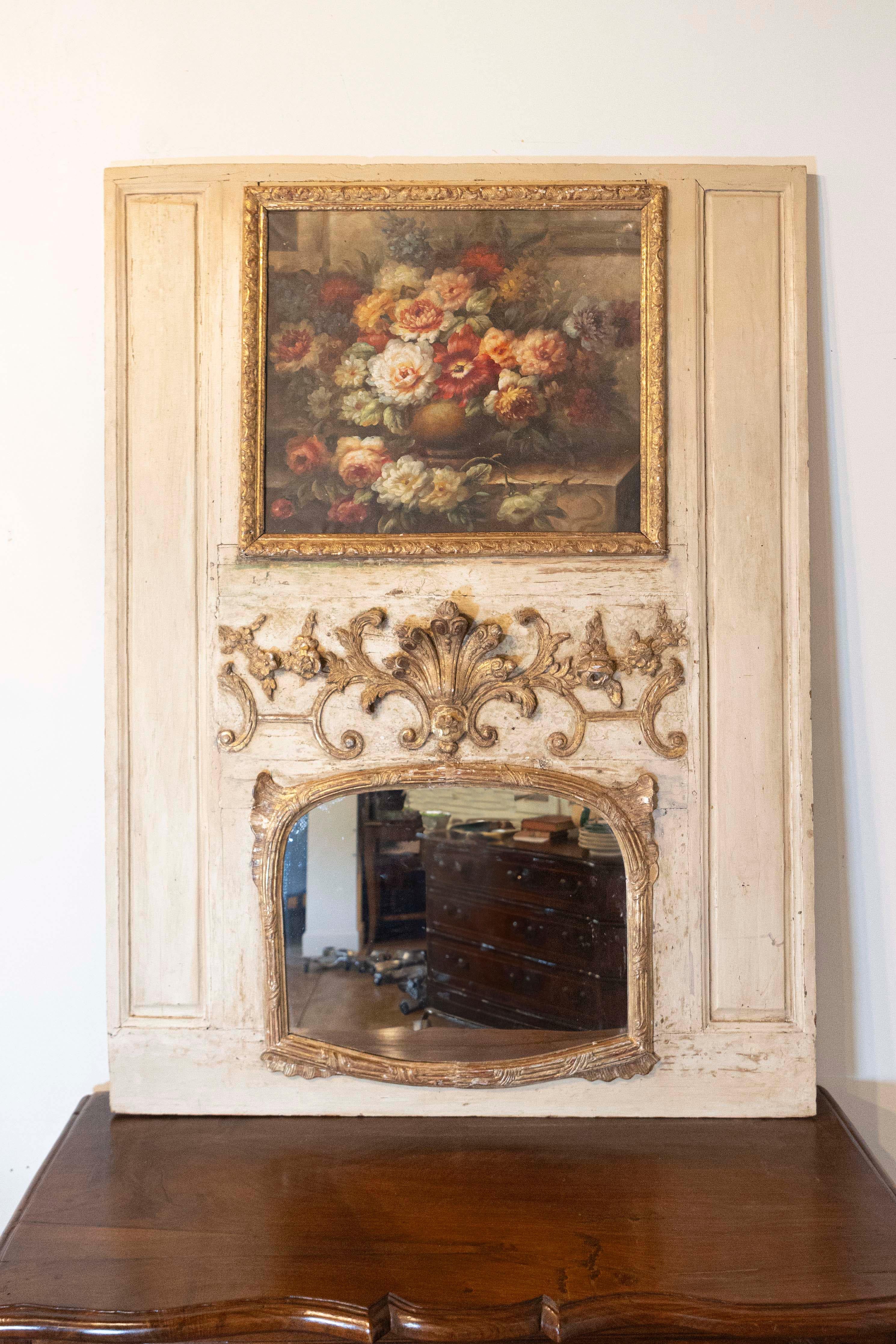 A French Louis XV painted trumeau mirror from the 18th century, with original floral oil painting and carved giltwood motifs. Born in France during the second half of the 18th century, this exquisite trumeau mirror attracts our attention with its