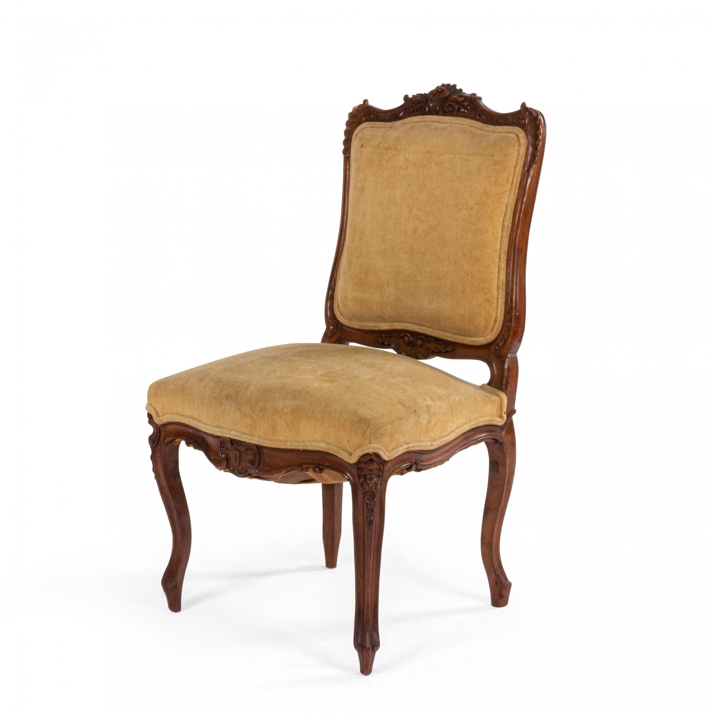 Pair of 20th century French Louis XV-style walnut side chairs with beige velvet upholstery.