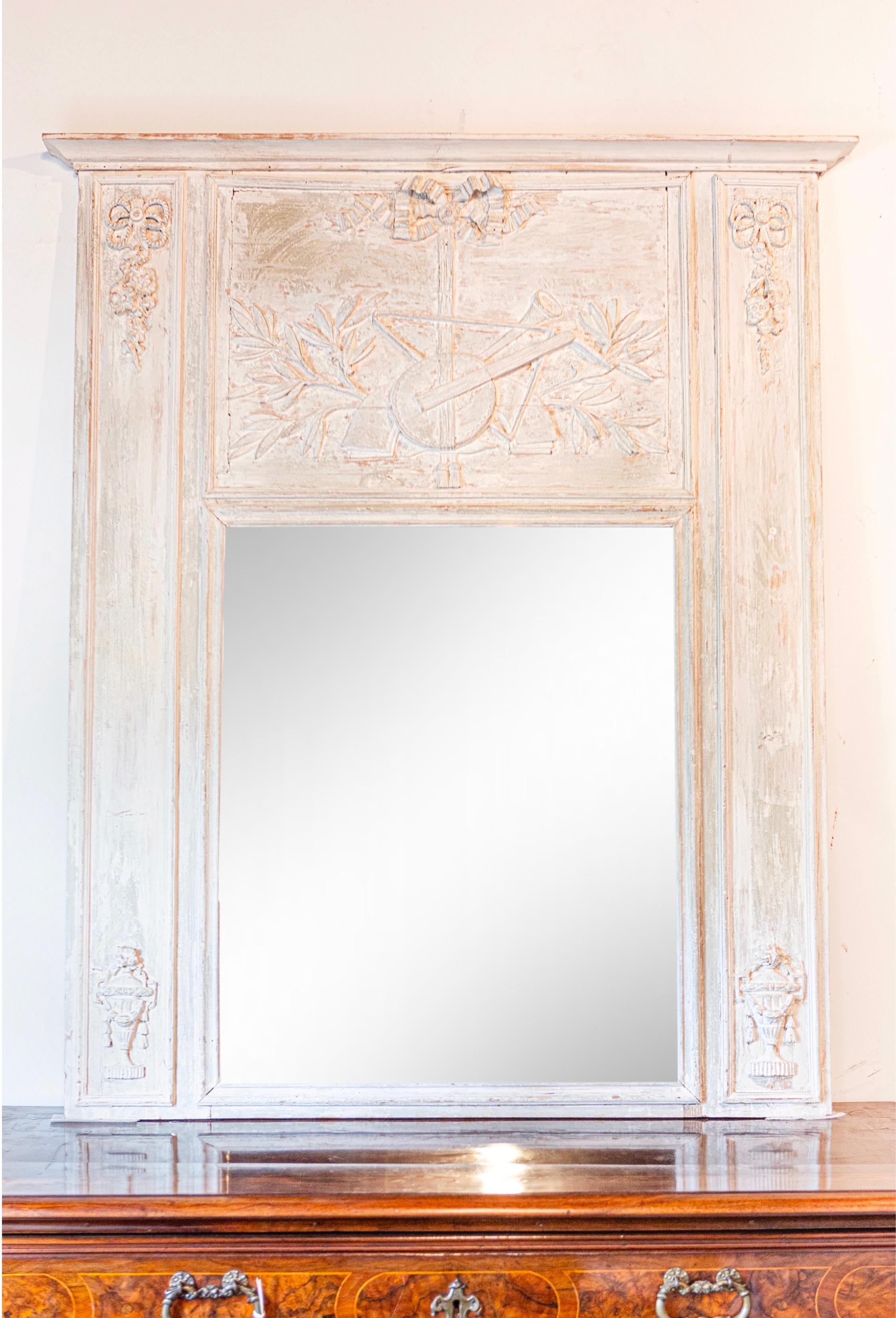 A French Louis XVI period trumeau mirror from circa 1790 with partial stripped finish and carved Liberal Arts allegory. This captivating French Louis XVI period trumeau mirror, dating back to circa 1790, is a testament to the elegant artistry of the