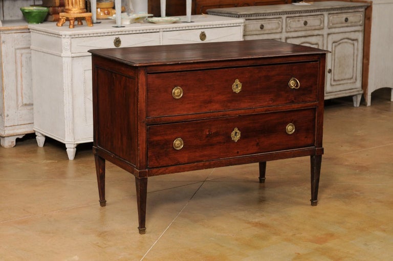 A French Louis XVI period wooden sauteuse from the late 18th century, with two drawers and tapered legs. Created in France at the end of King Louis XVI's reign, this wooden commode features a rectangular top with petite canted corners, sitting above
