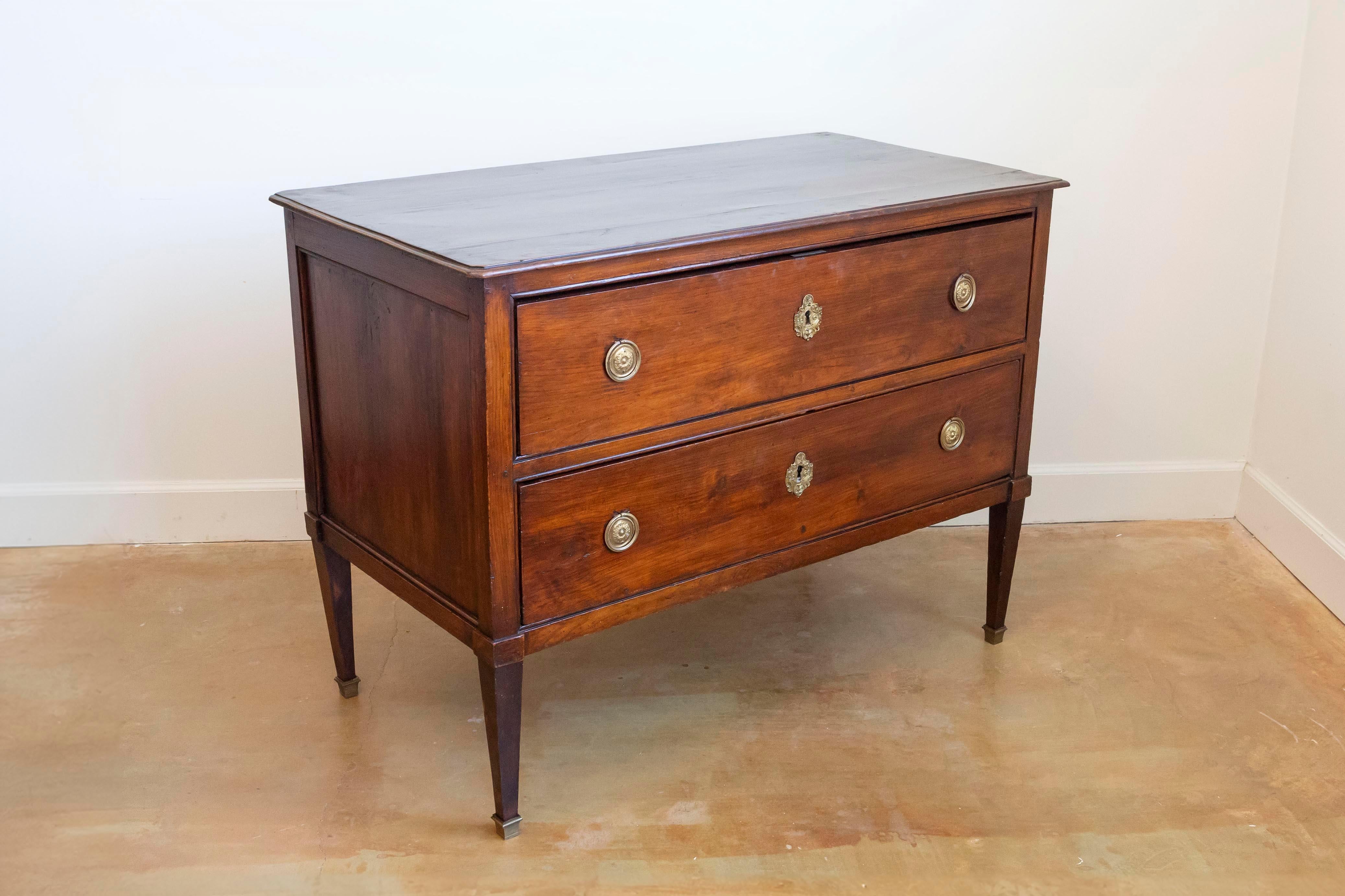 Sauteuse en bois d'époque Louis XVI de la fin du XVIIIe siècle, avec deux tiroirs et des pieds fuselés. Créée en France à la fin du règne de Louis XVI, cette commode en bois présente un plateau rectangulaire avec de petits coins inclinés, surmontant