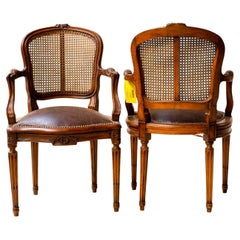 Paire de fauteuils français Louis XVI avec dossier en rotin et assise et accoudoirs en cuir