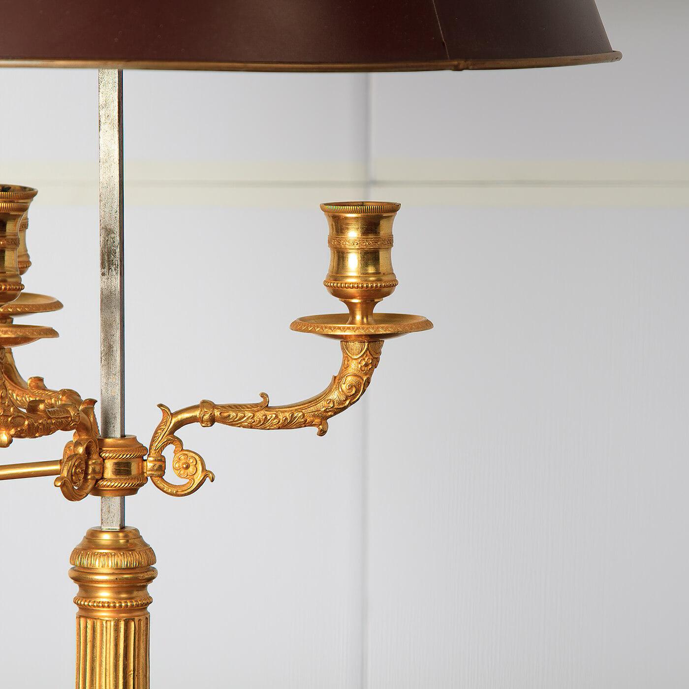 A fine French Louis XVI style gilt bronze three light. Bouillotte lamp, with an adjustable tole, painted shade, three adjustable arms, fluted column, and a pierced basket base.

Dimensions: 16