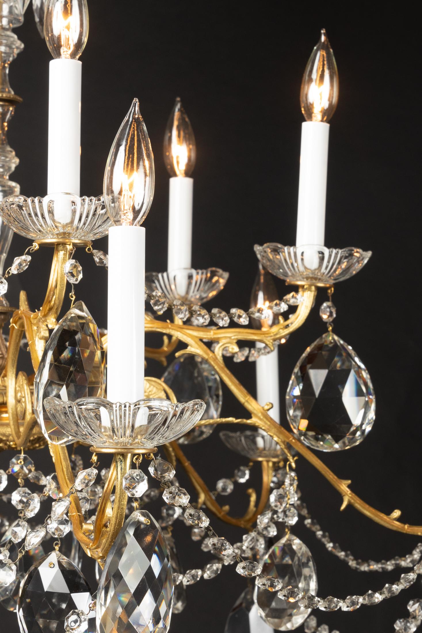 Dieser klassische Louis-XVI-Kronleuchter stammt aus dem 19. Jahrhundert und verfügt über wunderschönes Kristall, das den mittleren Schaft umgibt. Seile aus achteckigem Kristall fließen von den langen Bronzearmen und verleihen dem Kronleuchter einen