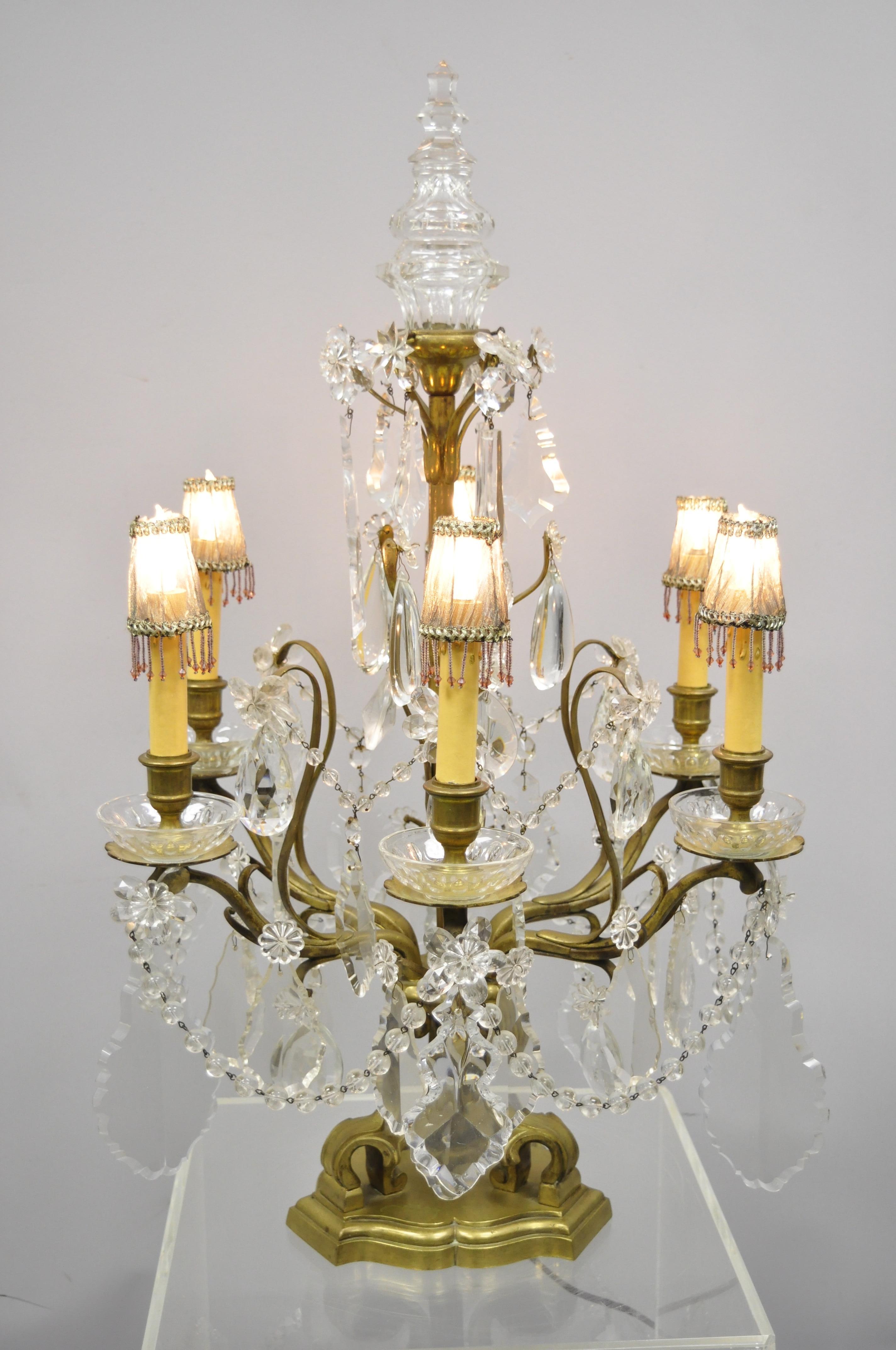 Antique French Louis XVI style bronze and crystal prism girandole electrified candelabra lamp. Item features bronze frame, large impressive crystal prisms, glass finial, beaded shades, 6 electrified arms, very nice antique item, circa early 1900s.