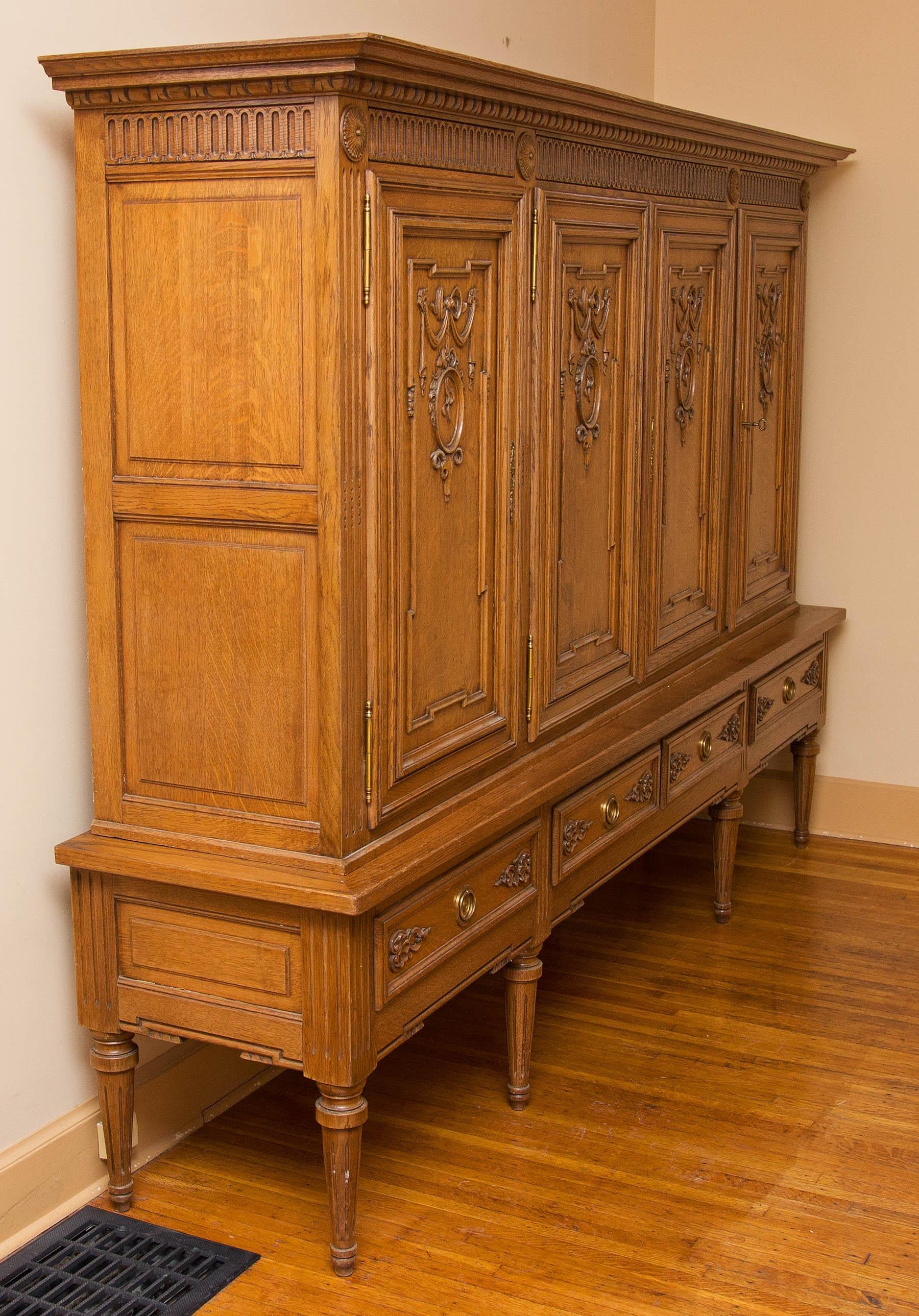 Louis XVI style four-door, four-drawer cabinet. An unusual size. Lots of storage. The top is finished. The height makes the top great for displaying objects. Solid quarter sawn white oak. Interior fitted with shelving and paper lined. French, early