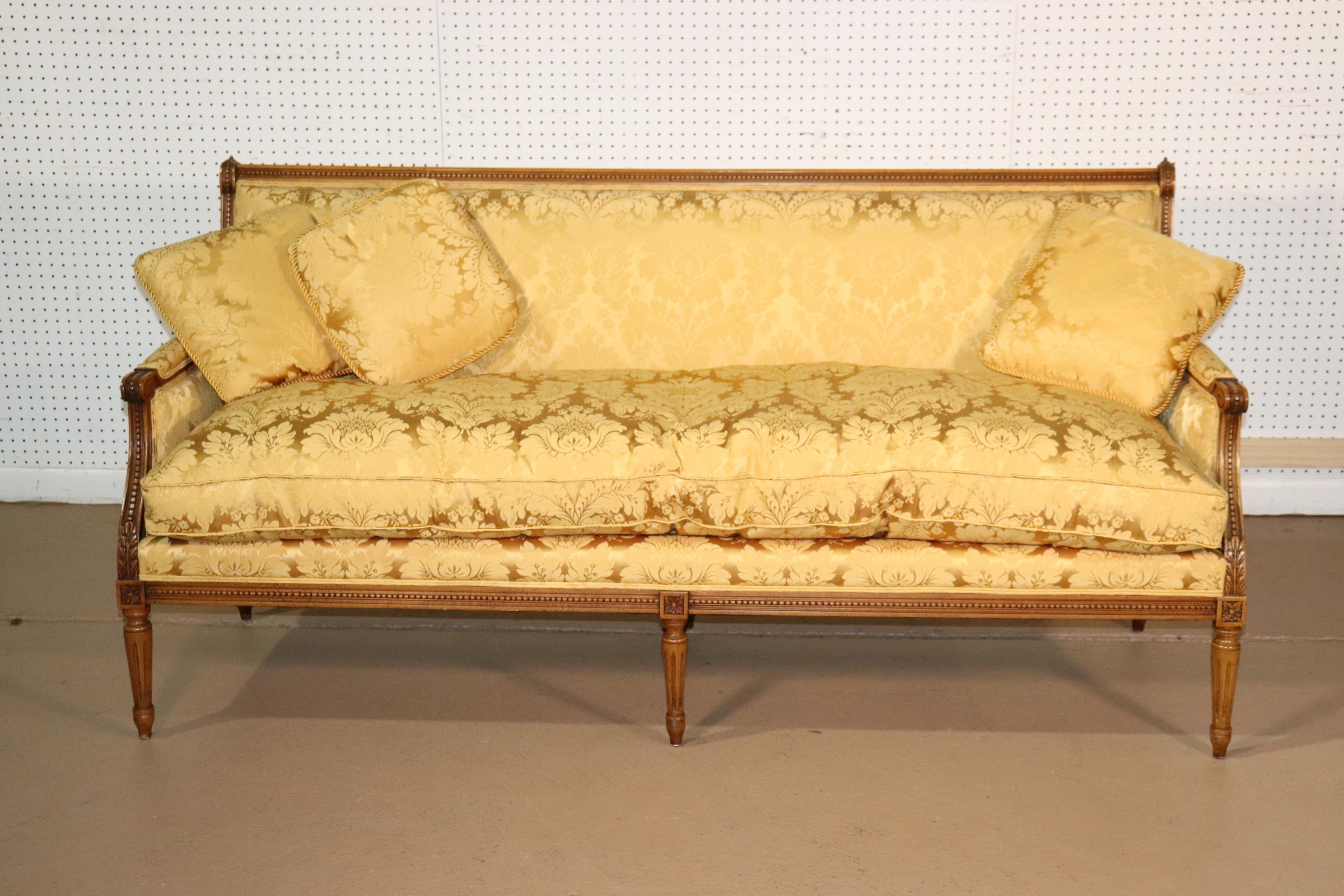 This is a stunning and very clean possibly silk damask settee with the classic elements of Louis XVI and beautiful carved detail. The upholstery which may be silk, is in very, very clean condition. It may have flaws but we can't seem to find them.
