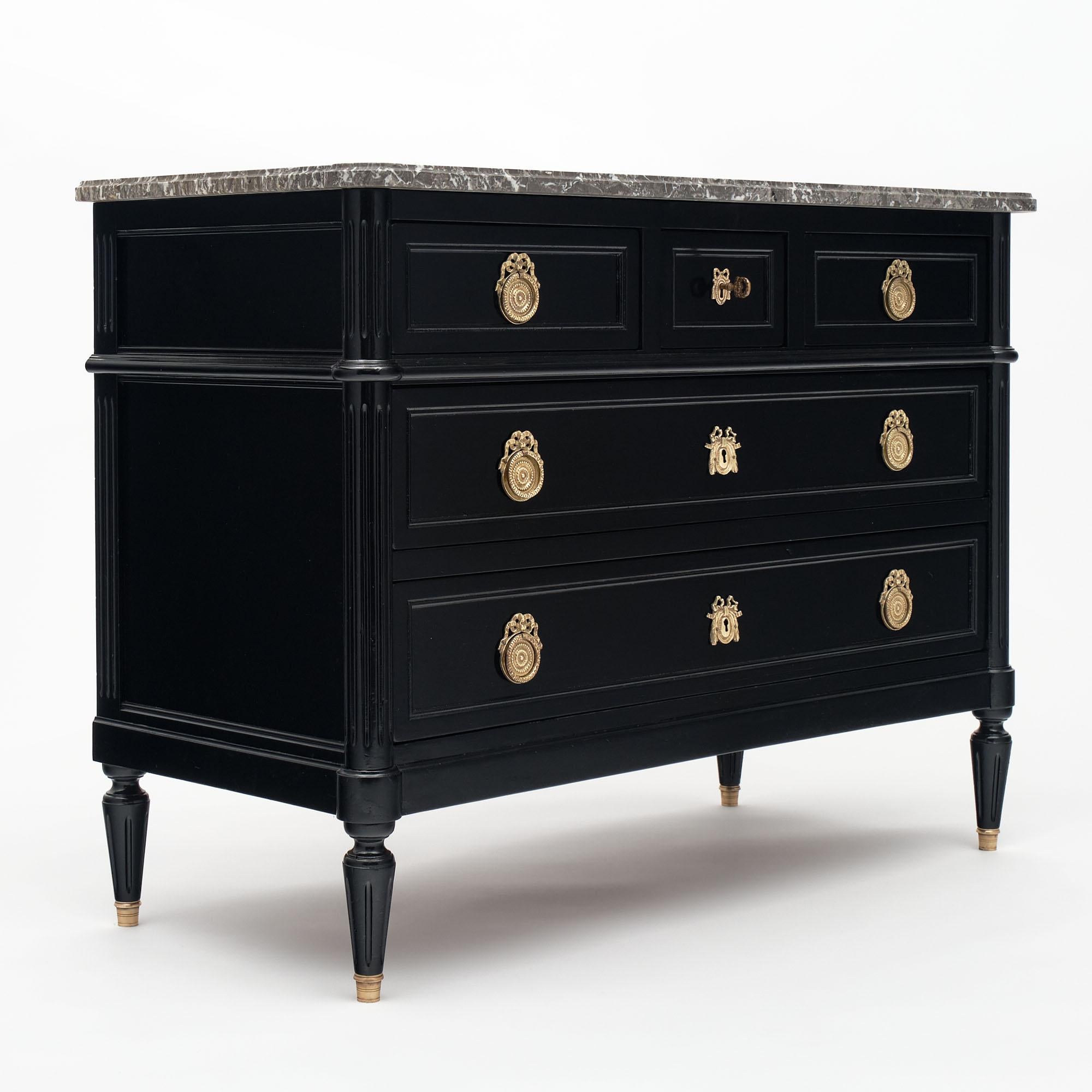 French chest of drawers in the Louis XVI style. This piece is made of cherrywood with a lustrous ebonized French polish finish. There are  5 dovetailed drawers with their original finely cast gilt  bronze hardware. The crowning beauty of this piece