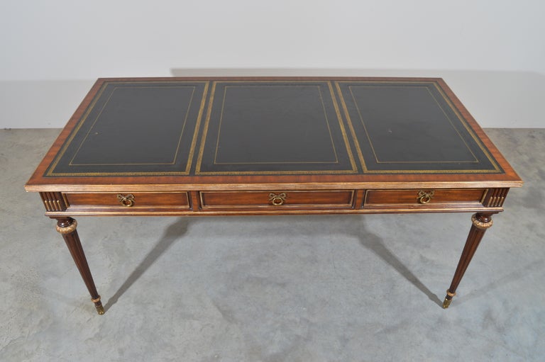 Beautifully detailed mahogany writing table or desk made by Maitland Smith in the grand French Louis XVI Directoire style having a large hand carved mahogany case which features a finished leather top writing surface with tooled leather and gilt