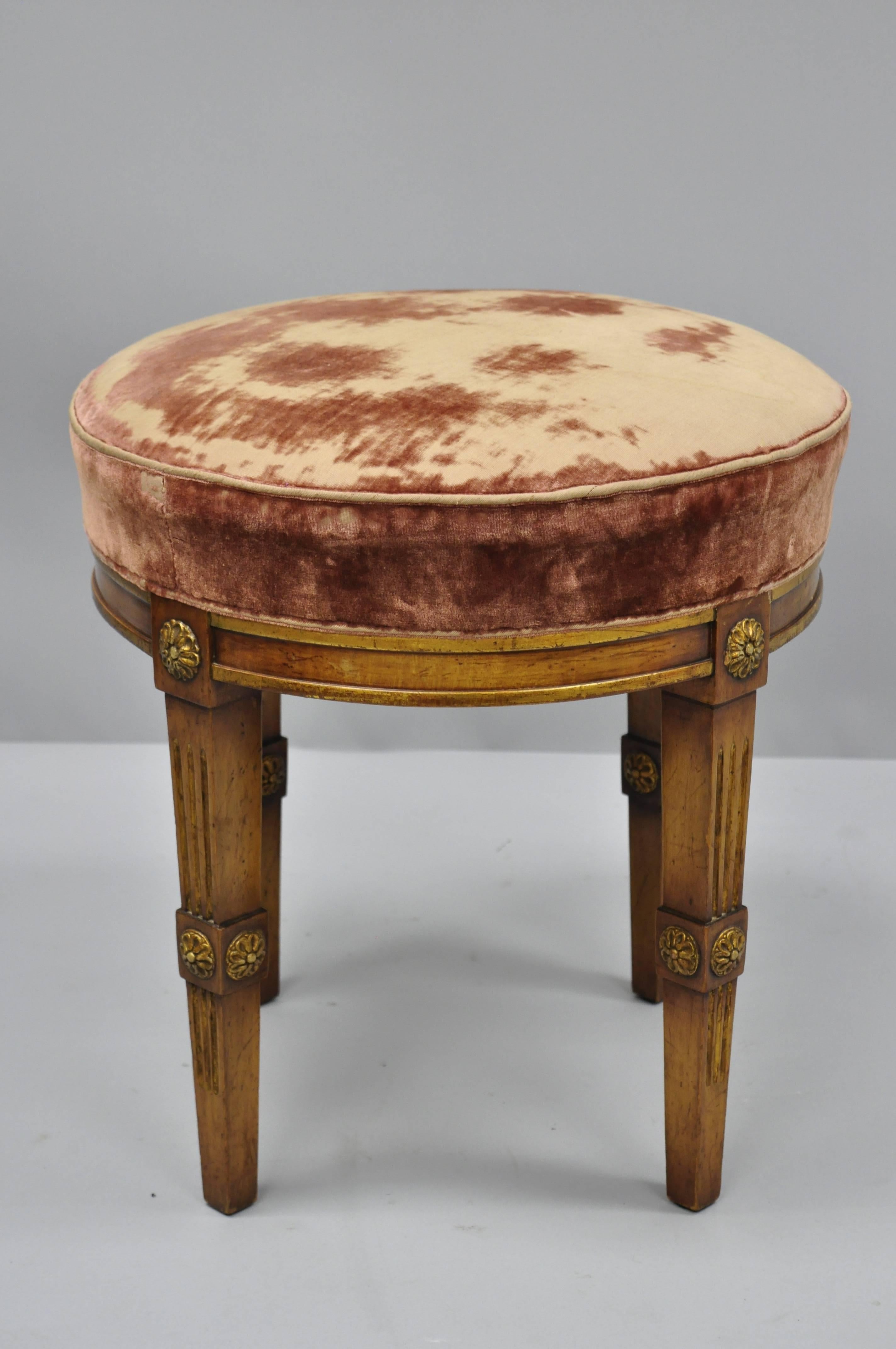 French Louis XVI Directoire style round neoclassical stool. Item features distressed gold gilt accents, wood rosettes, solid wood construction, tapered legs, circa early to mid-20th century. Measurements: 18.5