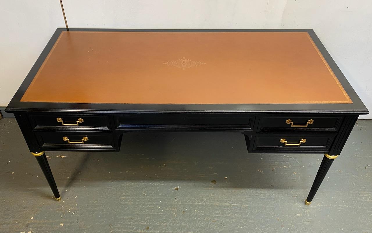 A good quality French Ebonised desk dating to the early 1900s. Having 5 drawers to the front, the central one lockable and key is present. It has 2 pull out slides to either end which retain their original tan leather along with the top, all the