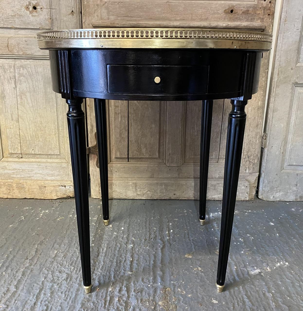 A wonderful quality French Lamp or Occasional Table, Louis XVI style and ebonised. The original grey variegated marble top is in excellent condition. It has 2 drawers and 2 slides. 
We have re finished it to a very high standard so in excellent