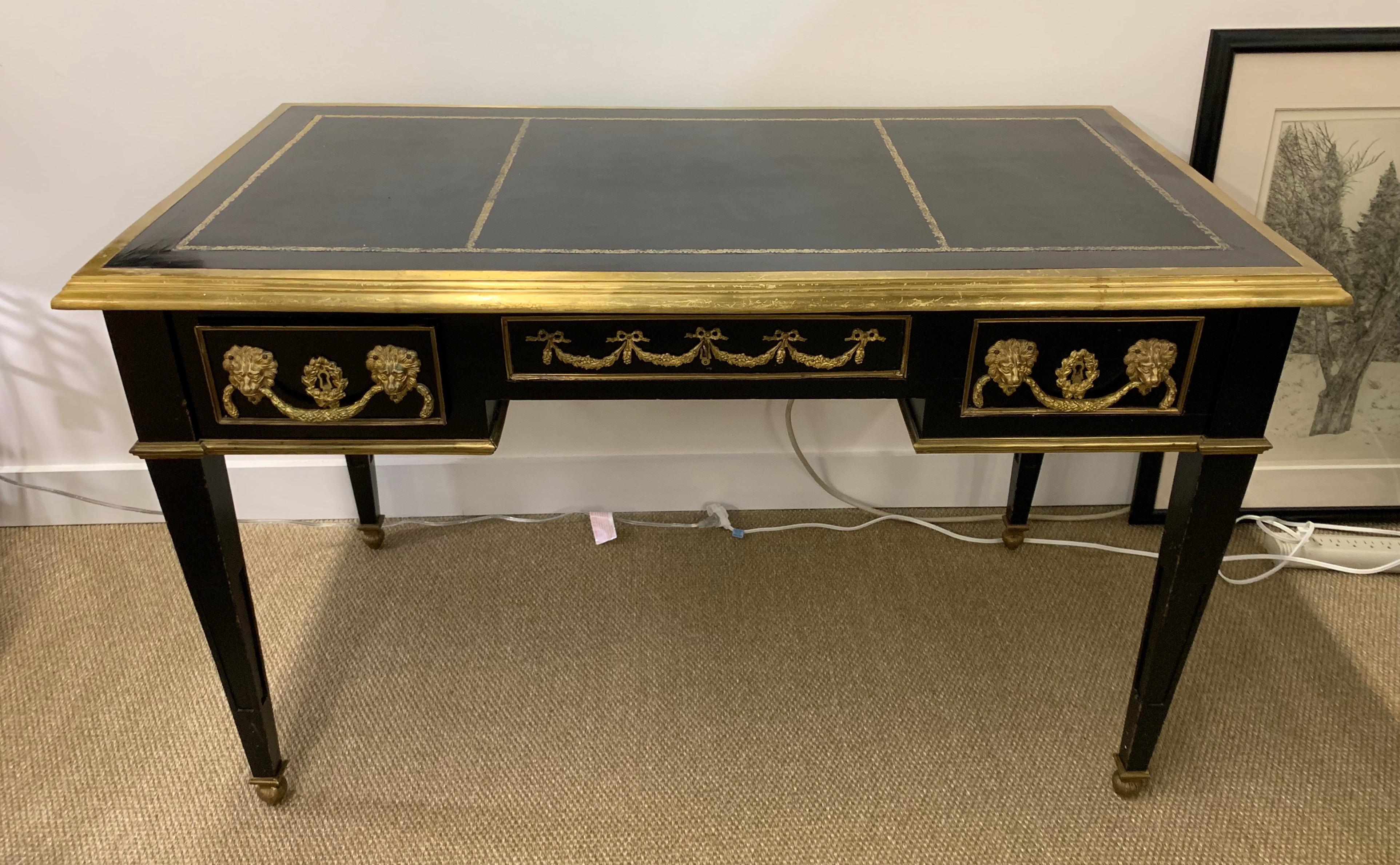 Jansen style French Louis XVI ebony desk with beautifully detailed heavy bronze mounts with a tooled black leather top. It has a heavy bronze border running around the entire desk and rests on tapered legs. There are three dovetailed drawers