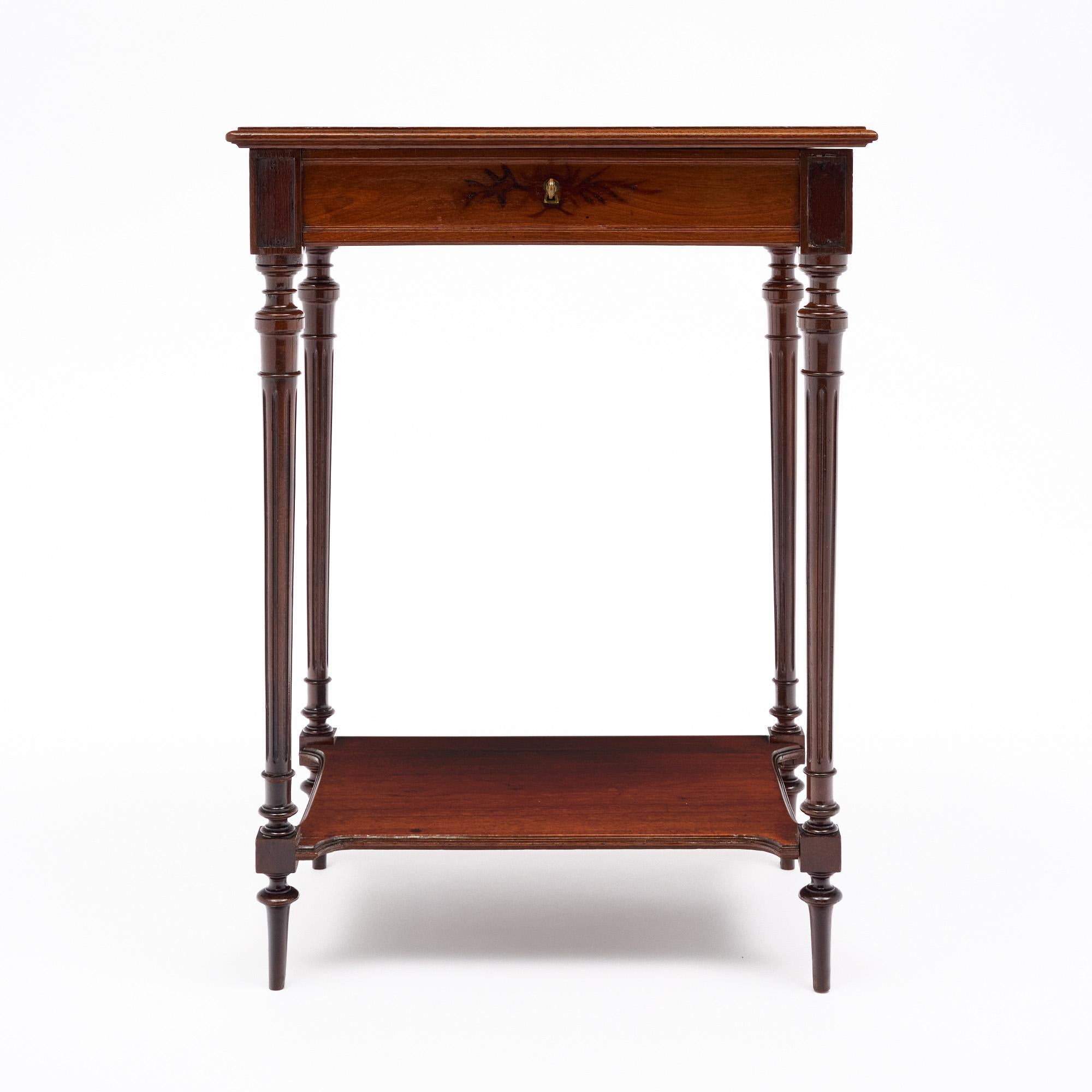 French side table ”travailleuse” of solid hand carved walnut with a marqueted rosewood top. The legs are tapered and fluted with wood turning details and the embroidery table features a bottom shelf. The piece is in very nice antique condition with