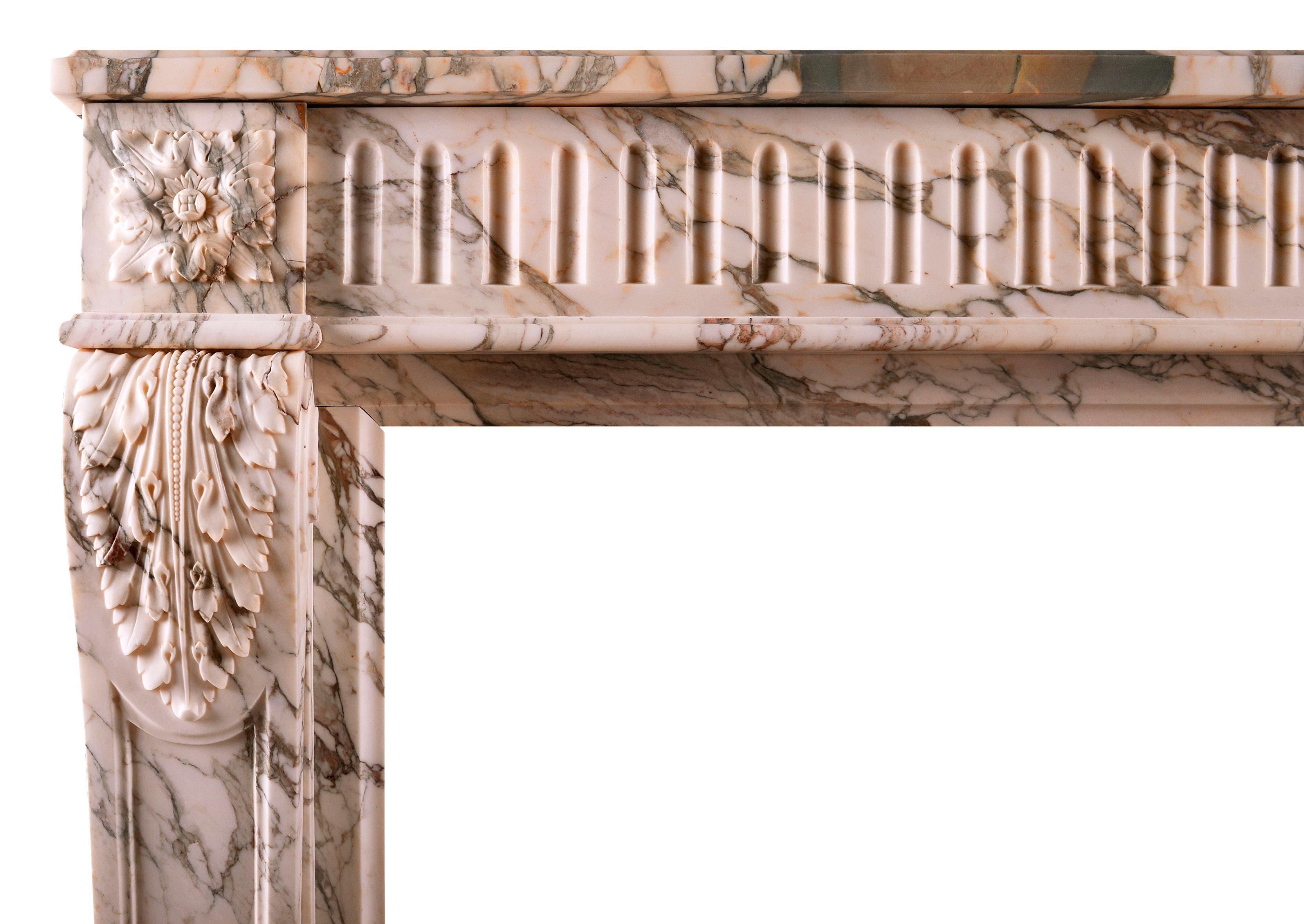 A fine quality French Louis XVI marble fireplace in striking Serravezza Breccia marble. The fluted frieze with carved square paterae to end blocks, the jambs with finely carved acanthus leaves and tapering panels below. Panelled outgrounds, late