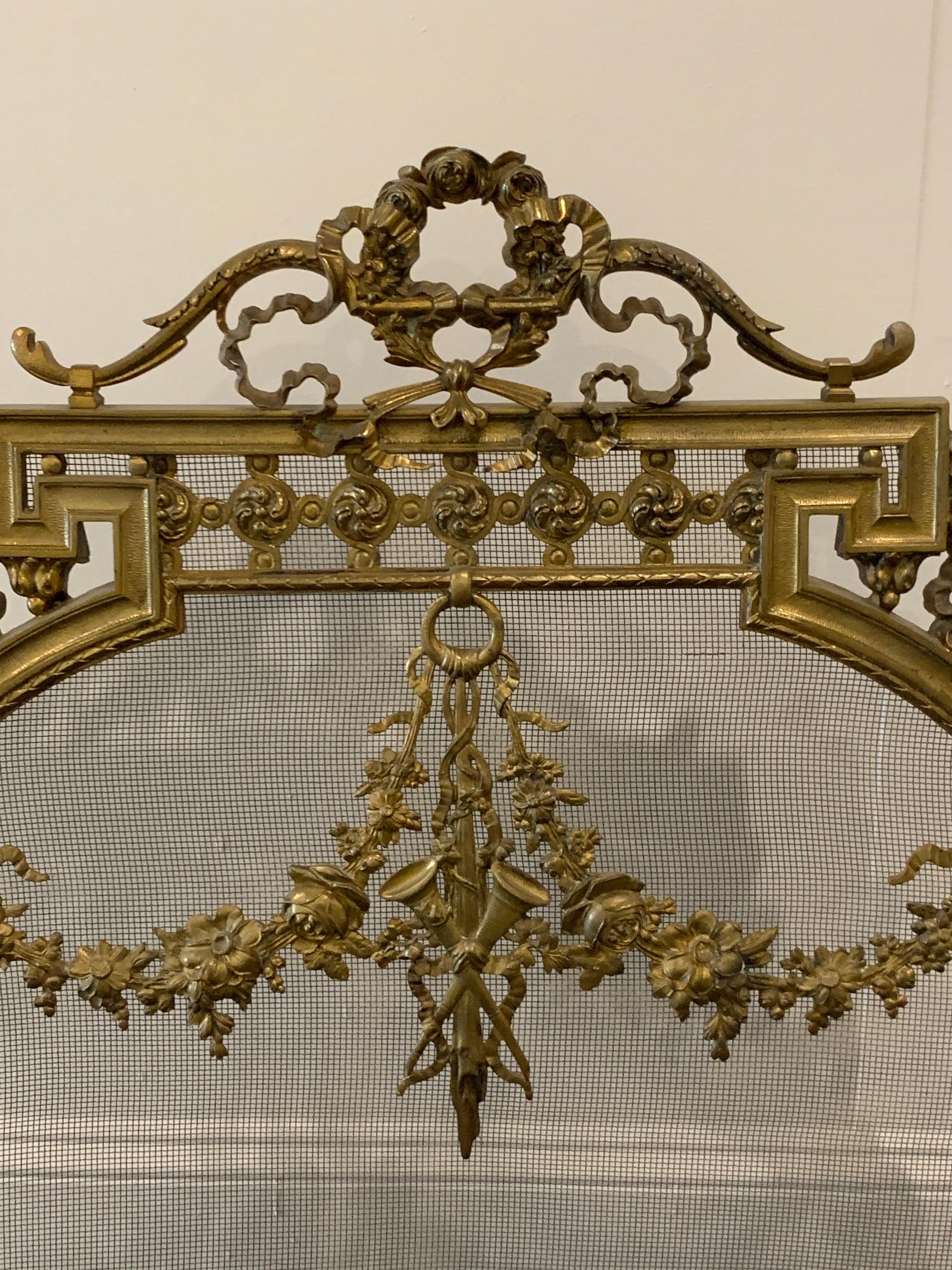 Lovely French Louis XVI gilt bronze fire screen. Interesting circular shape with images of flowers, ribbons, an urn and musical instruments. A fabulous decorative accessory!