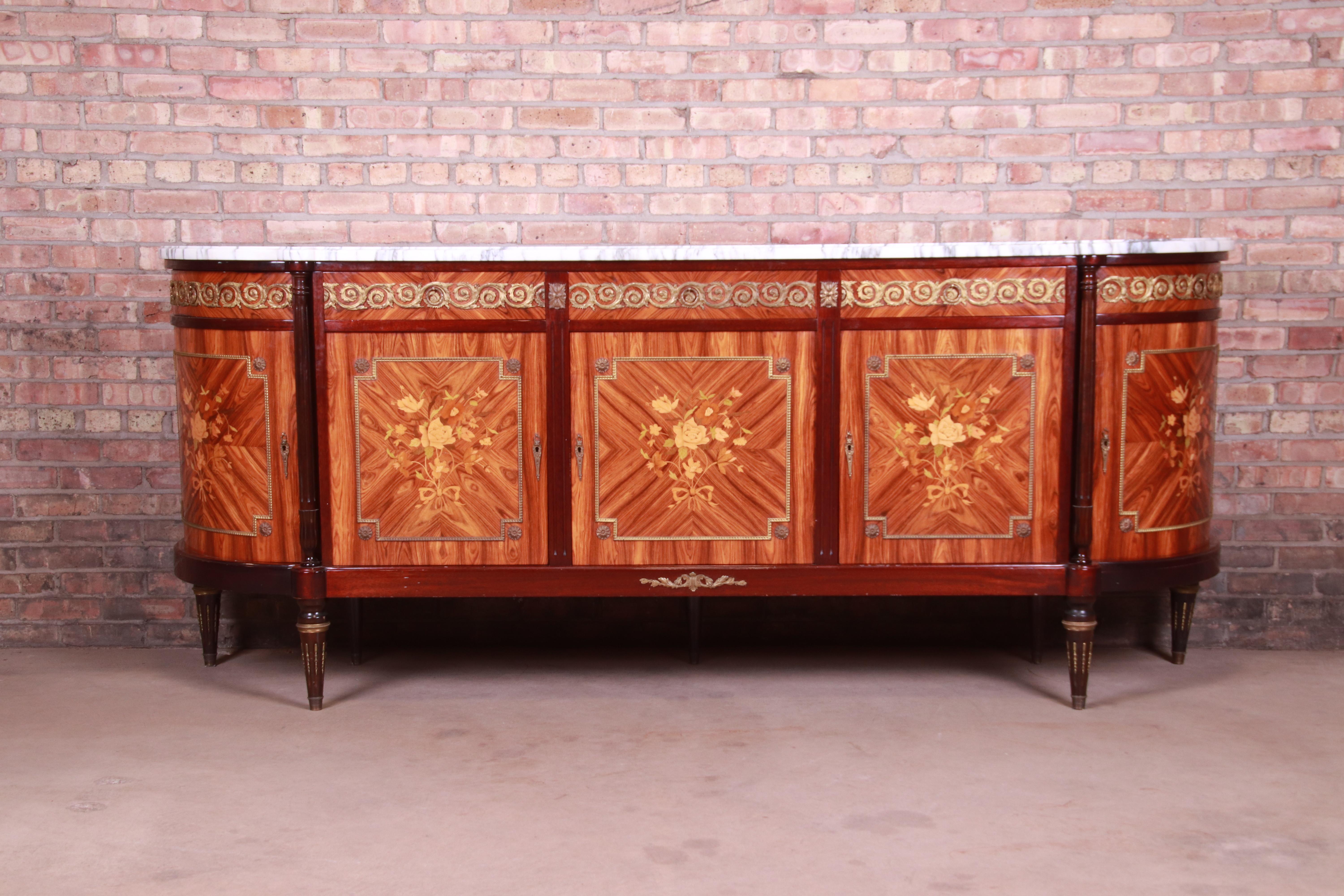 An exceptional French Louis XVI or Directoire style sideboard, credenza, or bar cabinet

By N.F. Ameublement

France, mid-20th century

Kingwood, with inlaid satinwood floral marquetry, bronze ormolu mounts, and Carrara marble