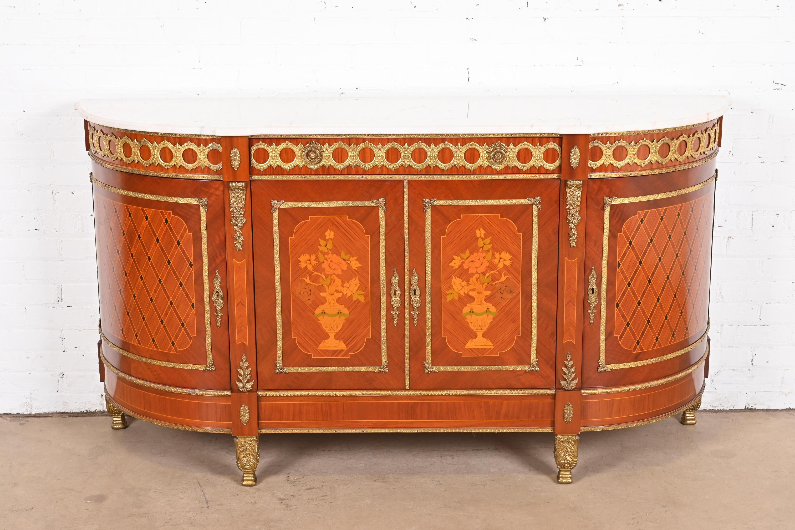 An exceptional French Regency Louis XVI or Directoire style sideboard, credenza, or bar cabinet

In the manner of N.F. Ameublement

France, Circa Mid-20th century

Kingwood, with inlaid satinwood marquetry and parquetry, bronze ormolu mounts, and
