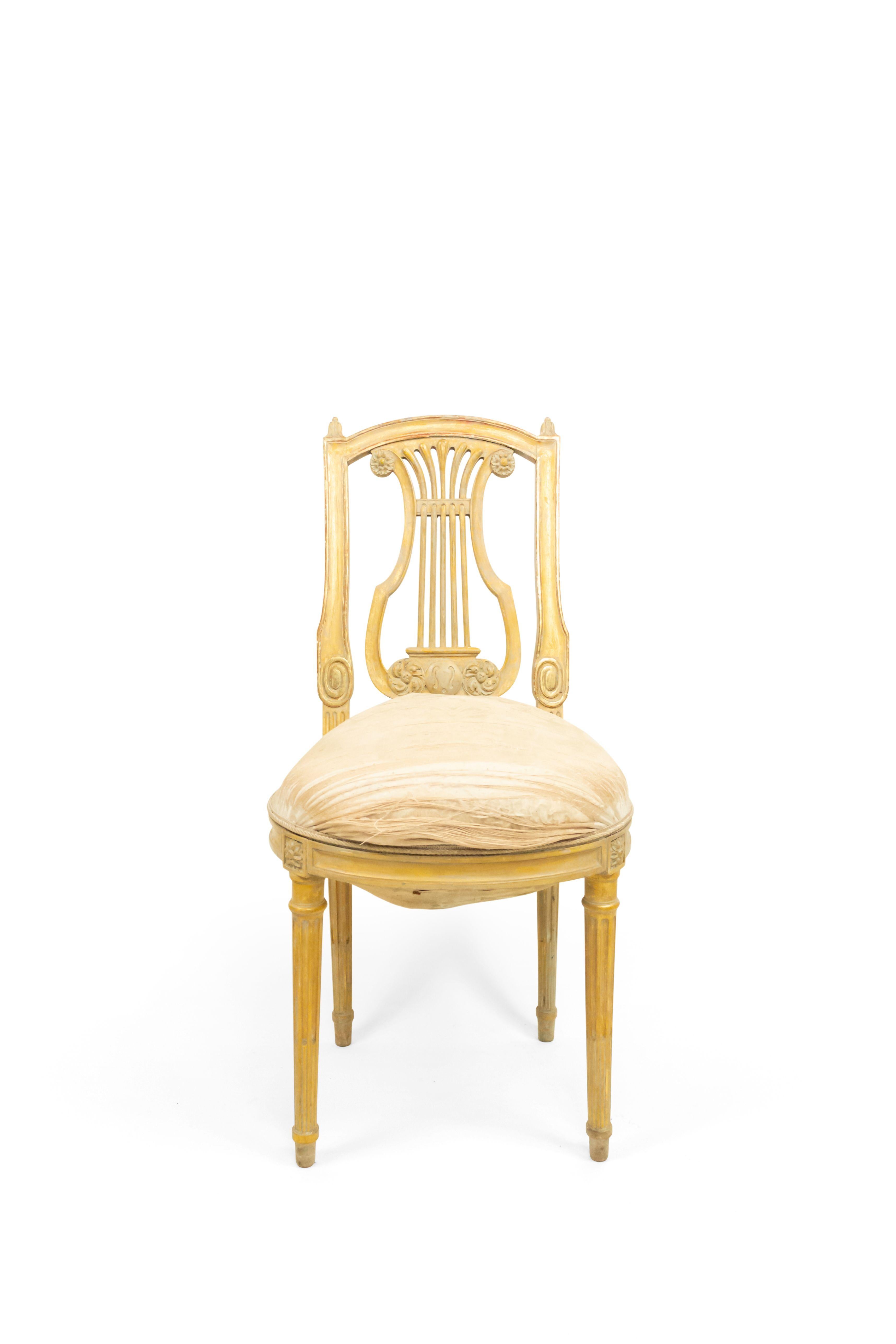 Set of 6 French Louis XVI style (19th century) white and gilt lyre back side chairs with white damask upholstery.