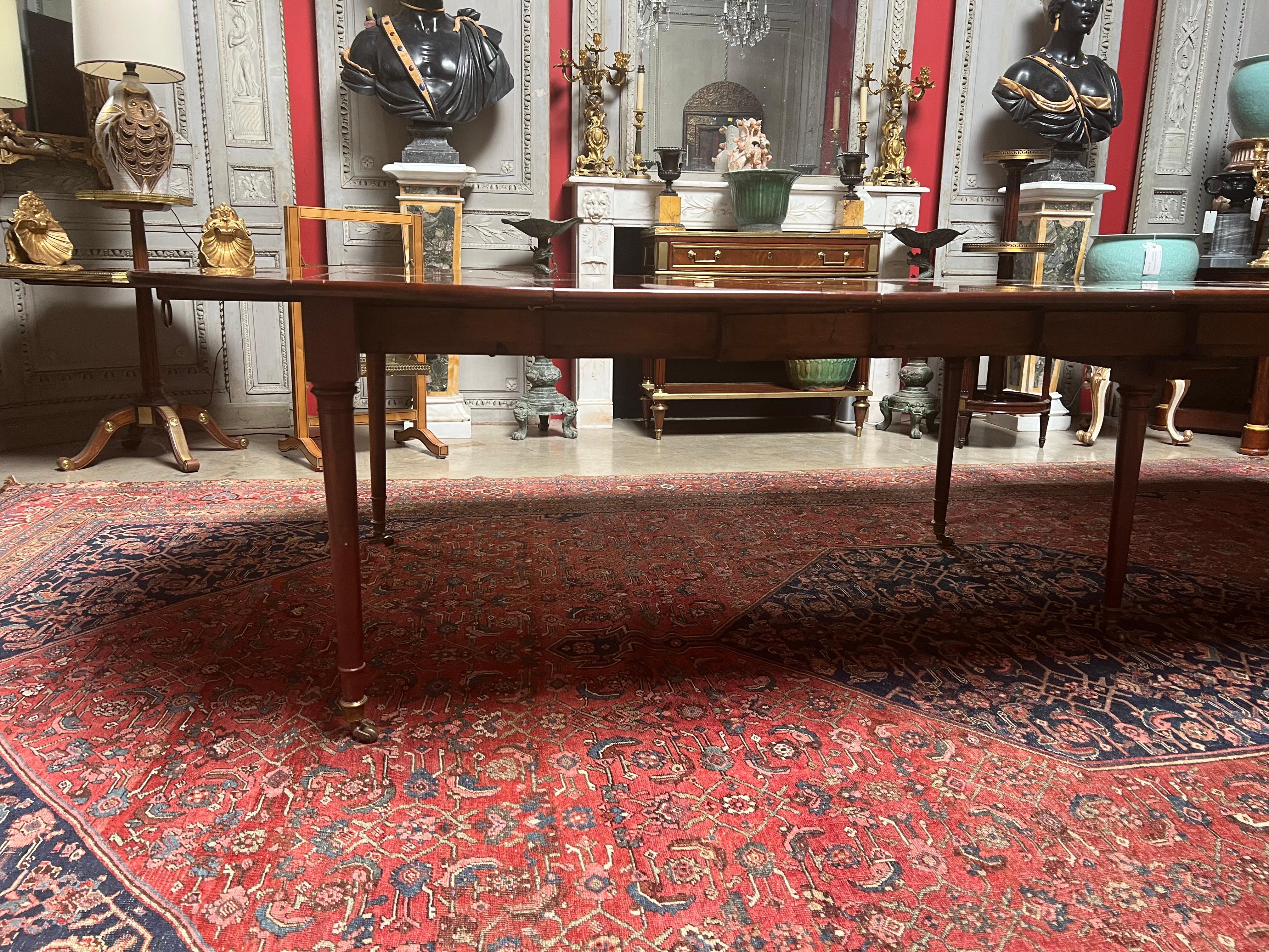 Ein französischer Mahagoni-Esstisch aus dem späten 18. Jahrhundert, der in der Mitte des 20. Jahrhunderts ergänzt wurde. 
Dieser vielseitige Tisch kann von 52,75