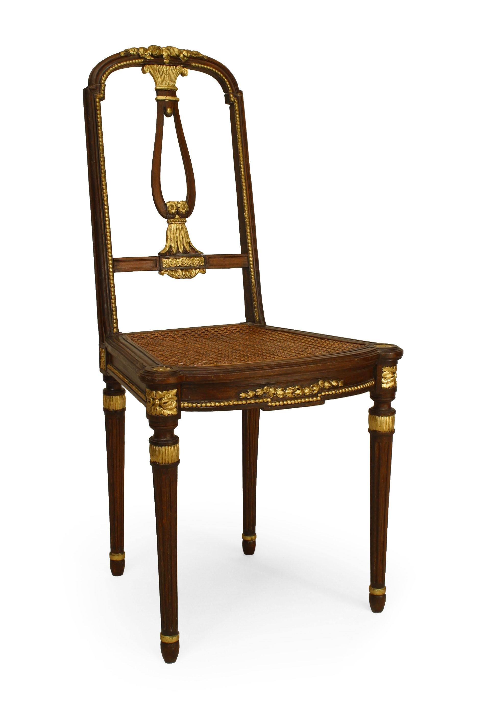 Pair of 20th century French Louis XVI-style mahogany side chairs with gilt trim and open backs with cane seats.