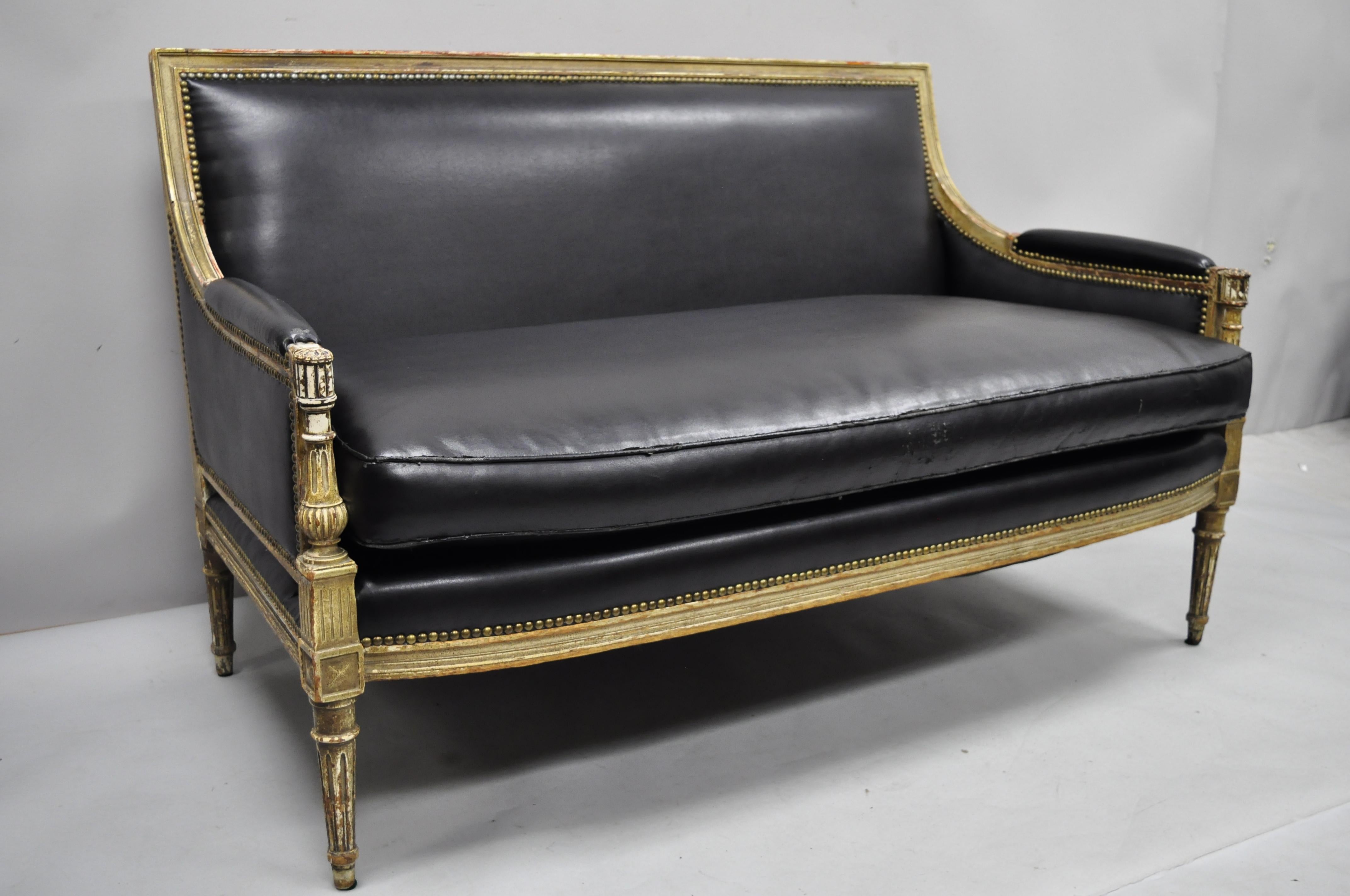 Antique French Louis XVI Maison Jansen style distress painted parcel-gilt settee loveseat. Item features a desirable distress painted parcel-gilt frame, black vinyl upholstery, stretcher supported back, finely carved details, tapered legs, quality