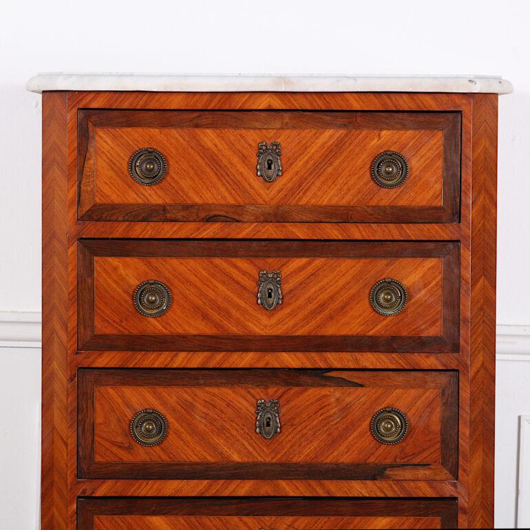 French kingwood and exotic woods marble top semainier or seven drawer chest, the drawers with banded edges and the original brass pulls and escutcheons. Quarter book-matched veneered sides. 

 