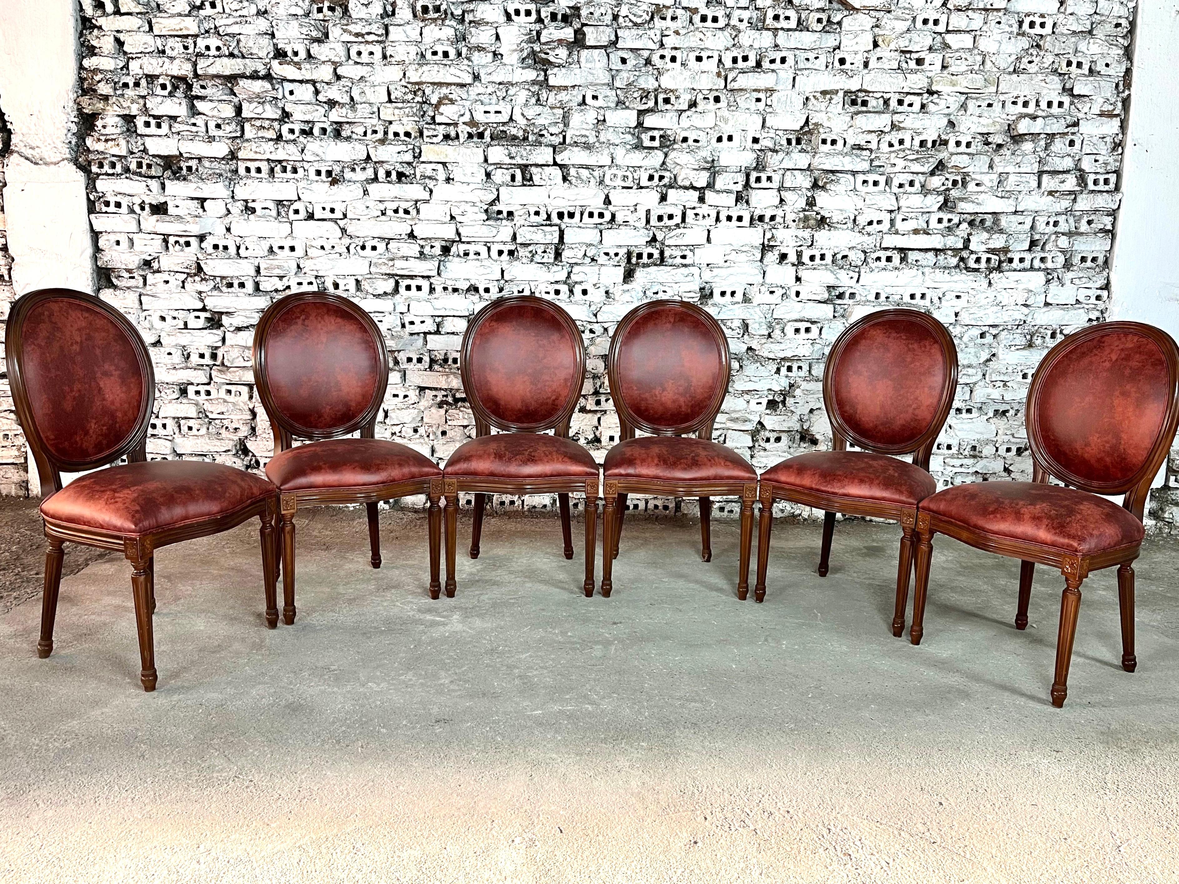Dimensions: H 37.7” x W 19.6” x D 17.5” x SH 18.8”

Set of 6 French Louis XVI style medallion back dining room chairs, newly upholstered in dark brown/red leatherette fabric. Solid carved legs. Wonderful design and quality craftsmanship. A wonderful