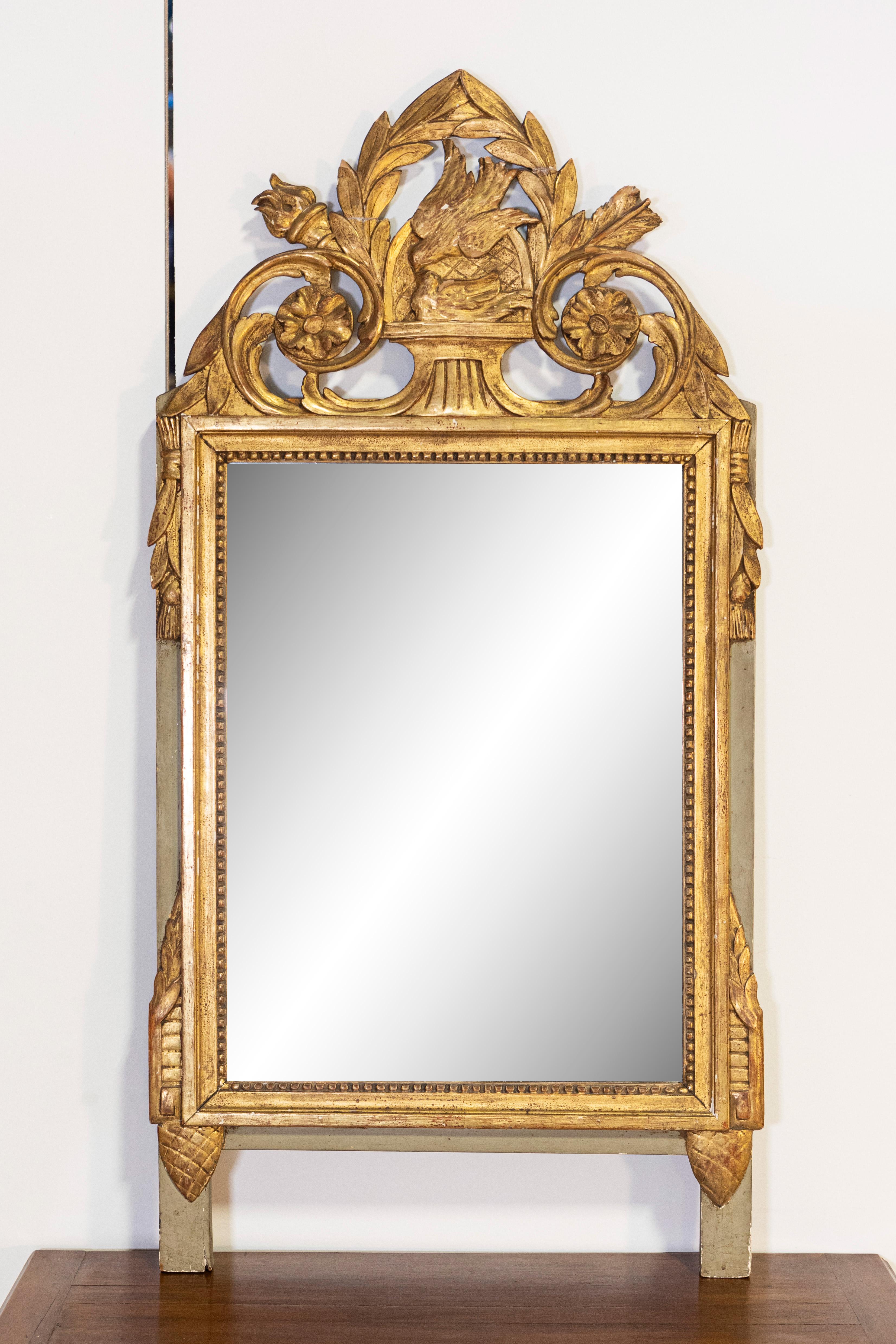 A French Louis XVI period giltwood mirror from circa 1790 with kissing doves and foliage décor. Crafted in France around 1790, this exquisite French Louis XVI period giltwood mirror was likely a wedding gift given its romantic motifs. At the crest,