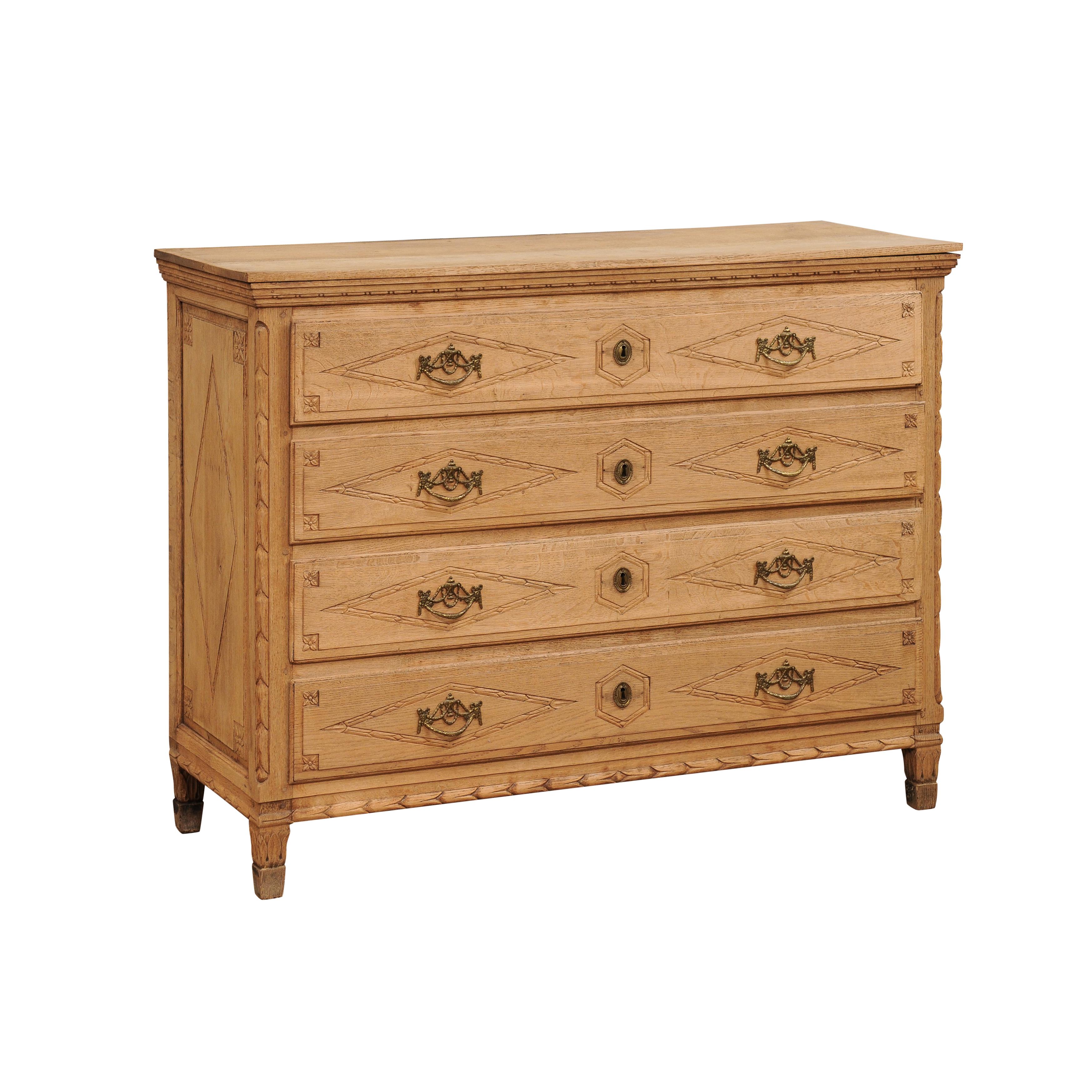 A French Louis XVI period natural oak commode circa 1790 with four geometric carved drawers. Enhance your living space with this exquisite French Louis XVI period natural oak commode from the late 18th century. Crafted with meticulous attention to