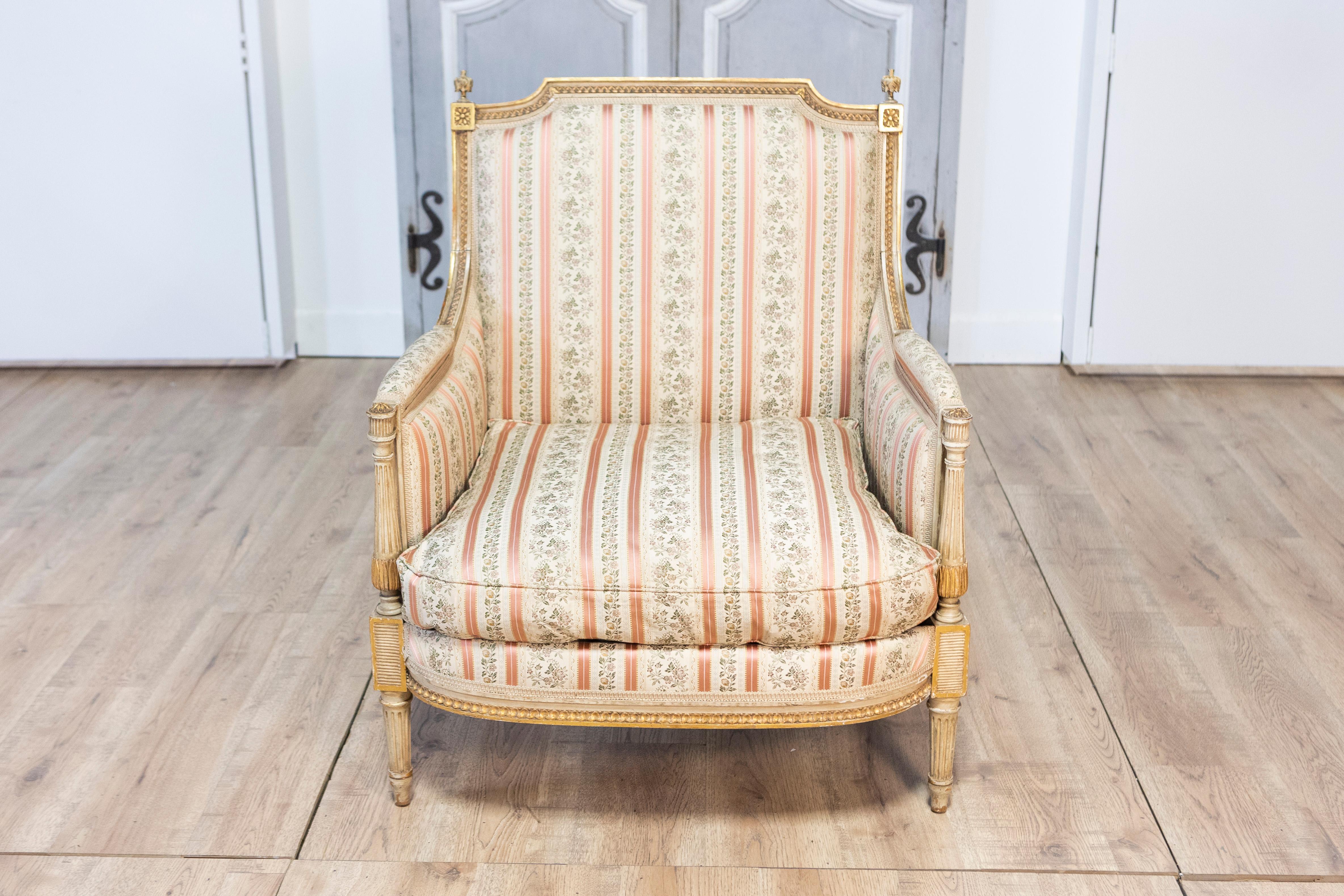 A French Louis XVI period painted and parcel gilt marquise chair from circa 1790 with carved fluted legs. Born in France circa 1790, this exquisite Louis XVI period marquise chair embodies the elegance and refinement characteristic of the era. The