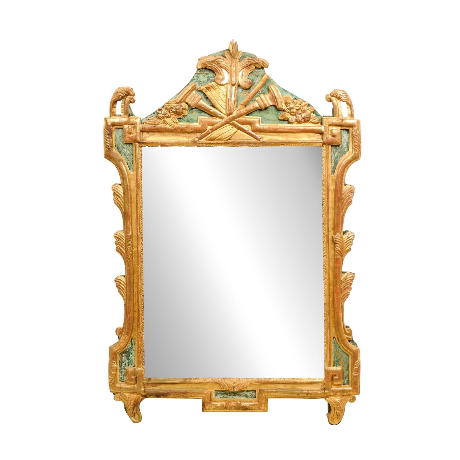 Miroir en bois peint et doré d'époque Louis XVI (XVIIIe siècle), sculpté d'une allégorie des arts libéraux symbolisée par des instruments de musique et des partitions. Ce miroir d'époque Louis XVI français du XVIIIe siècle est un splendide artefact